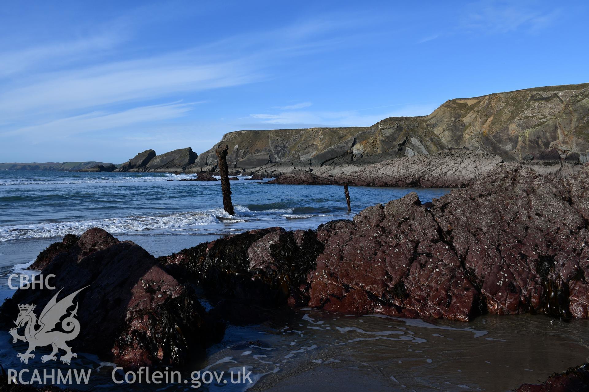 Wreck emerging from the waves. Camera facing SW. Taken by Hannah Genders Boyd. Produced with EU funds through the Ireland Wales Co-operation Programme 2014-2023. All material made freely available through the Open Government Licence.