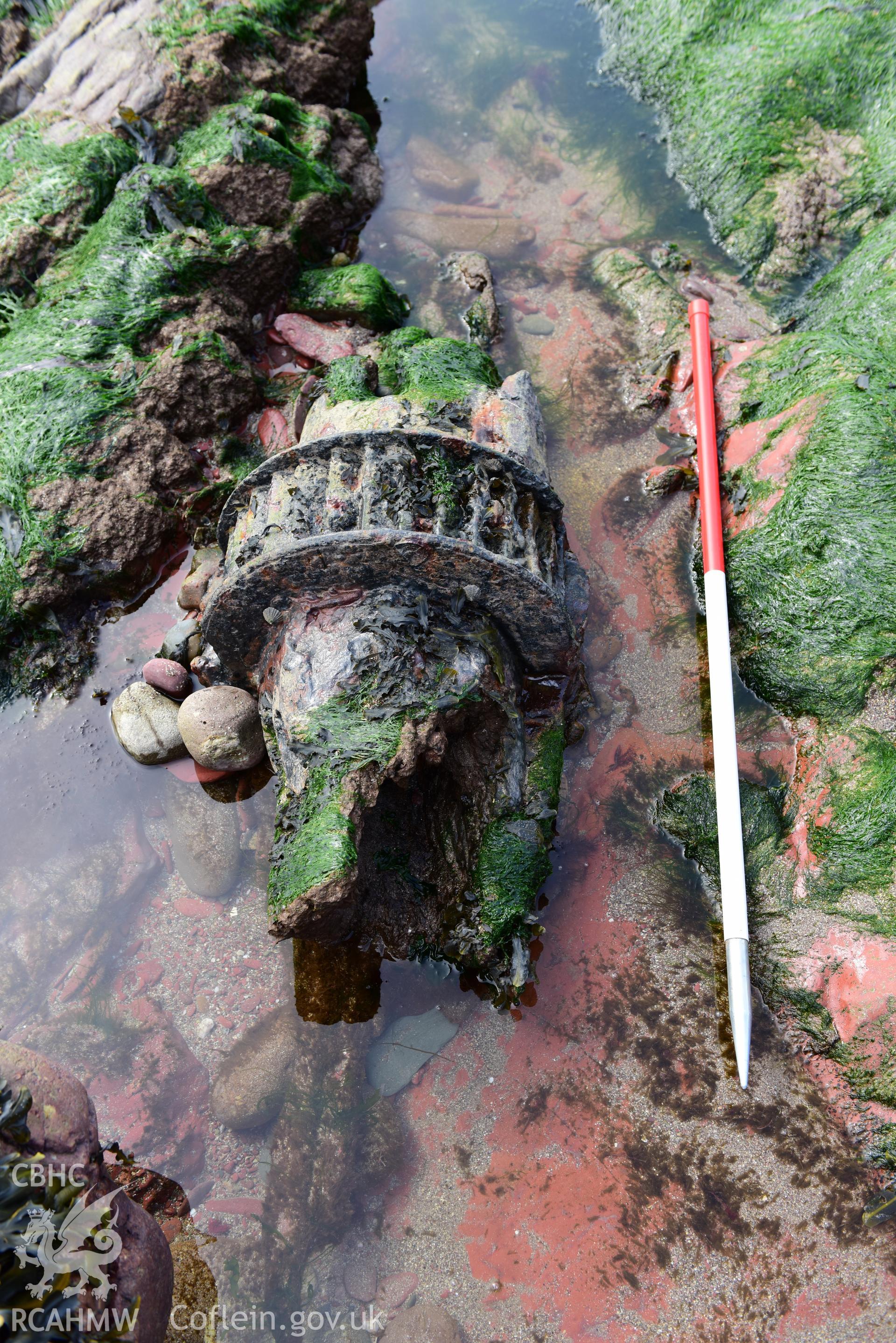 Part of the wreck amongst the rocks with 1m scale. Taken by Toby Driver. Produced with EU funds through the Ireland Wales Co-operation Programme 2014-2023. All material made freely available through the Open Government Licence.