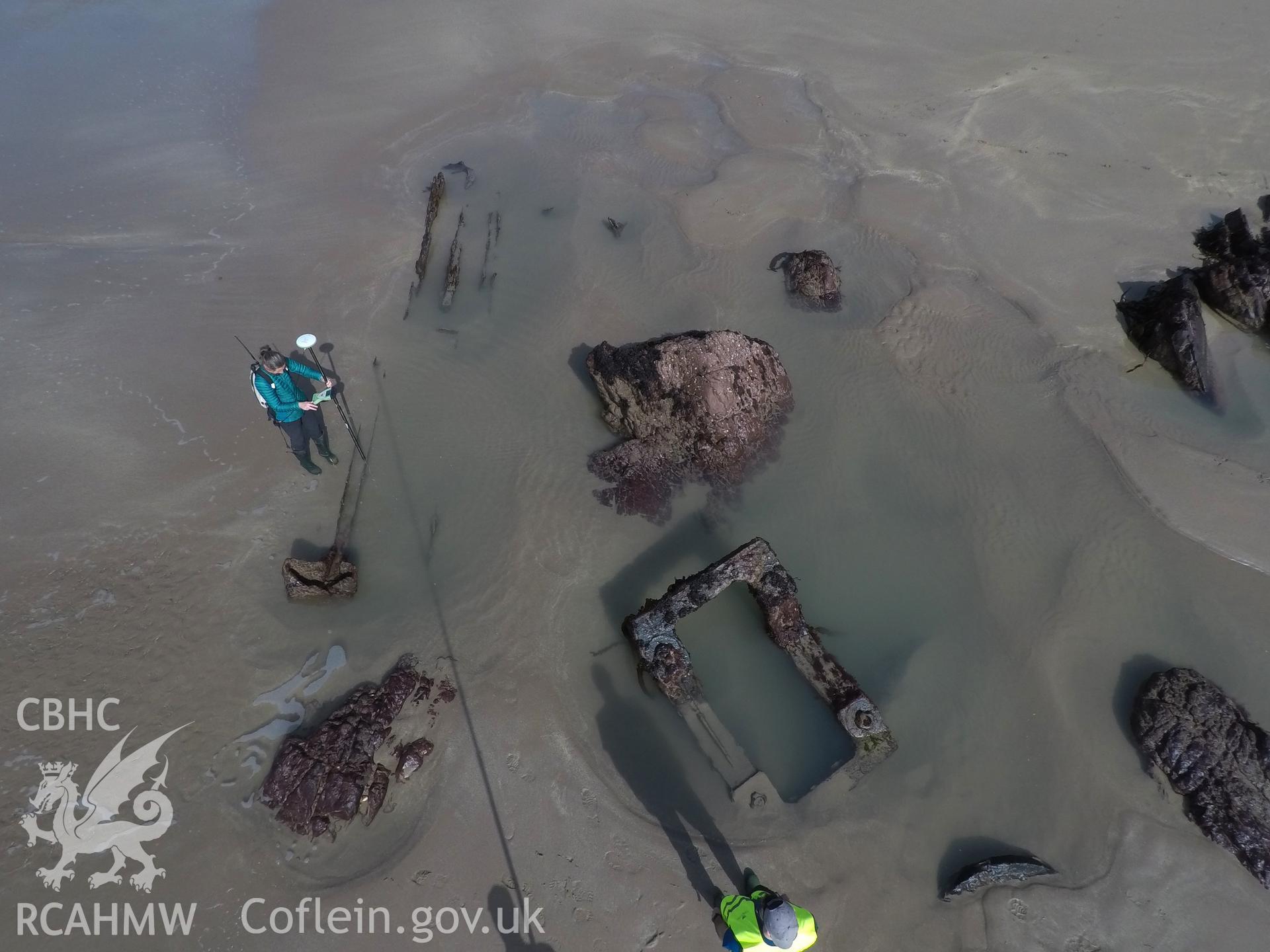 Pole camera shot of CHERISH team surveying the Albion paddle steamer shipwreck, exposed on the beach at low tide Taken by Daniel Hunt. Produced with EU funds through the Ireland Wales Co-operation Programme 2014-2023. All material made freely available th