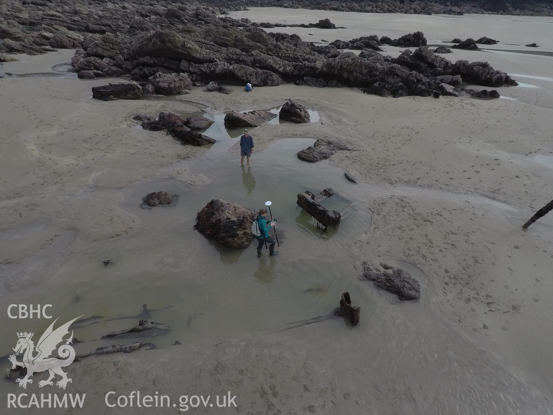 Pole camera shot of CHERISH team surveying the Albion paddle steamer shipwreck, exposed on the beach at low tide Taken by Daniel Hunt. Produced with EU funds through the Ireland Wales Co-operation Programme 2014-2023. All material made freely available th