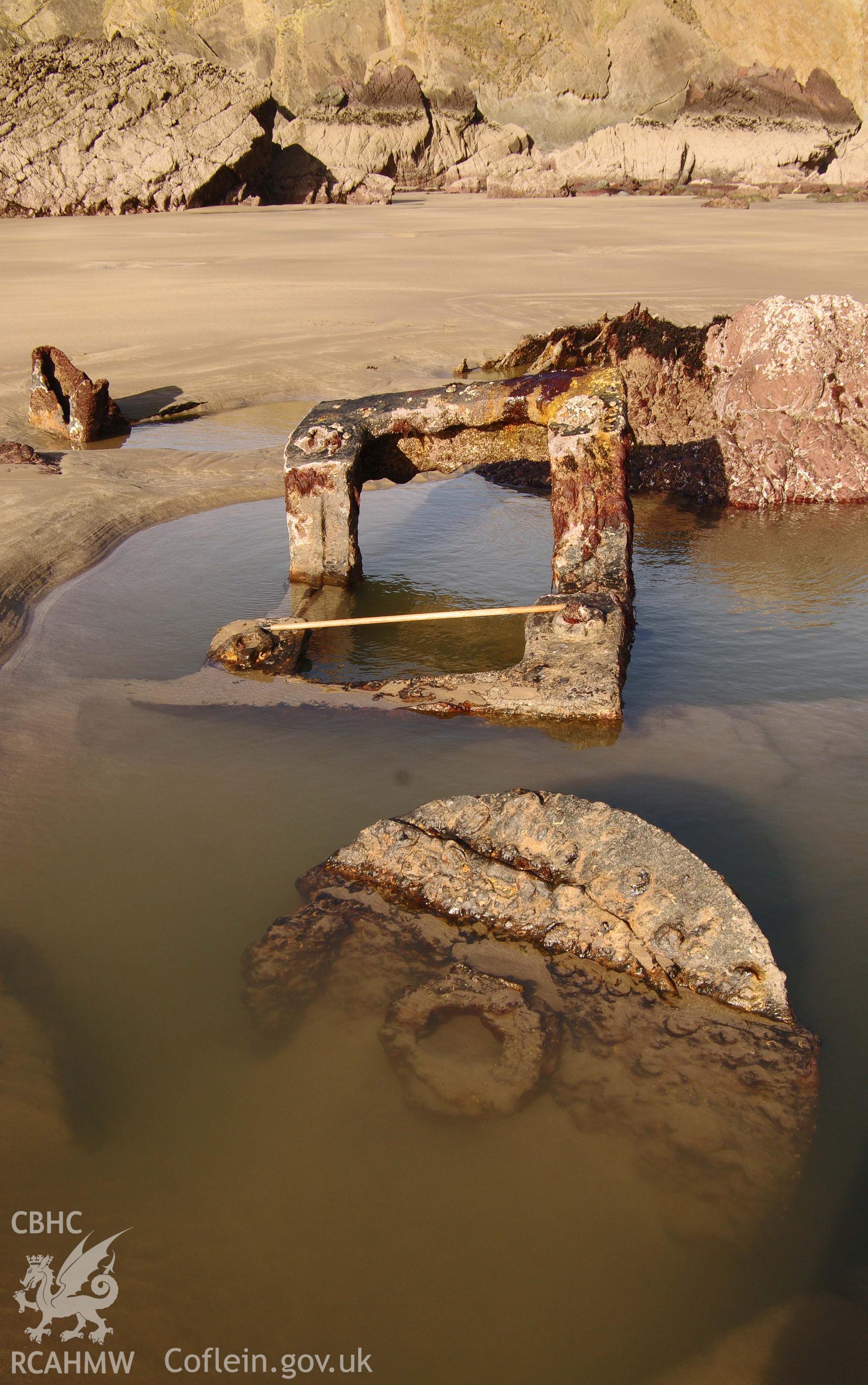 Parts of the wreck partially exposed on the beach, partially submerged. Taken by Hannah Genders Boyd. Produced with EU funds through the Ireland Wales Co-operation Programme 2014-2023. All material made freely available through the Open Government Licence