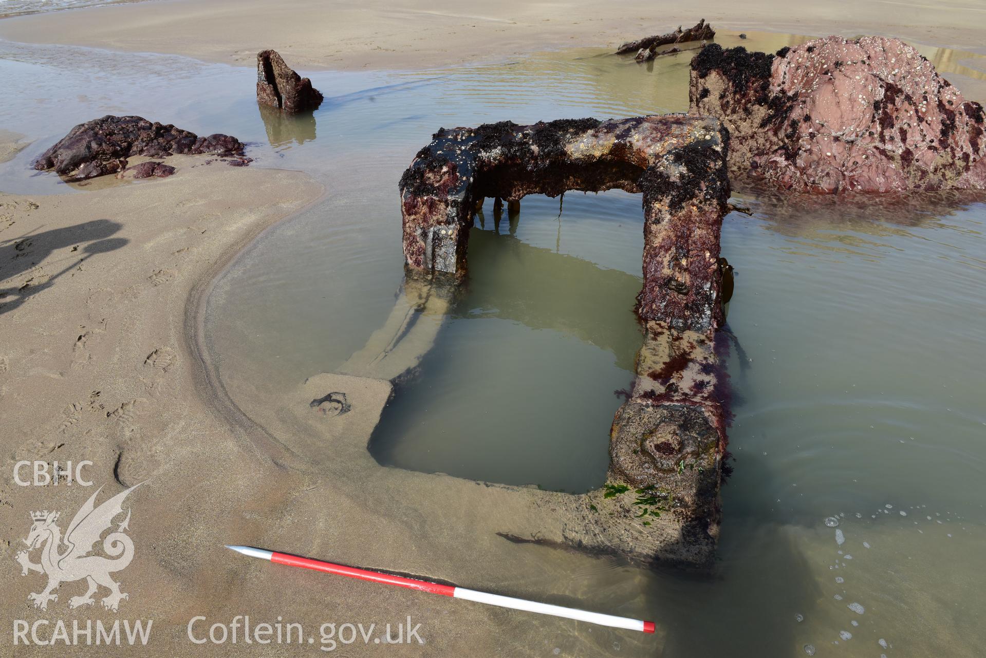Parts of the wreck embedded in the sand with 1m scale. Taken by Toby Driver. Produced with EU funds through the Ireland Wales Co-operation Programme 2014-2023. All material made freely available through the Open Government Licence.