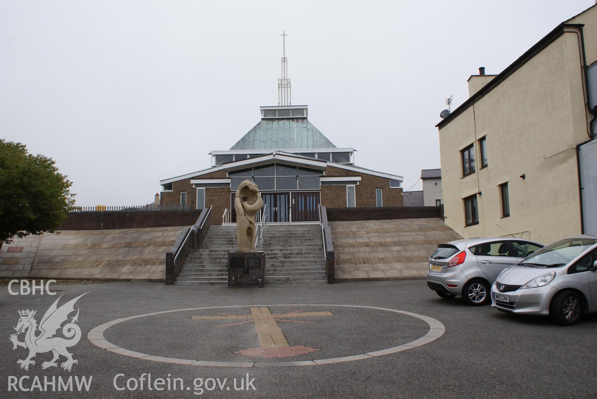 Digital colour photograph showing exterior with sandstone sculpture by Julie Winter at St Mary Help of Christians Catholic church, Holyhead.
