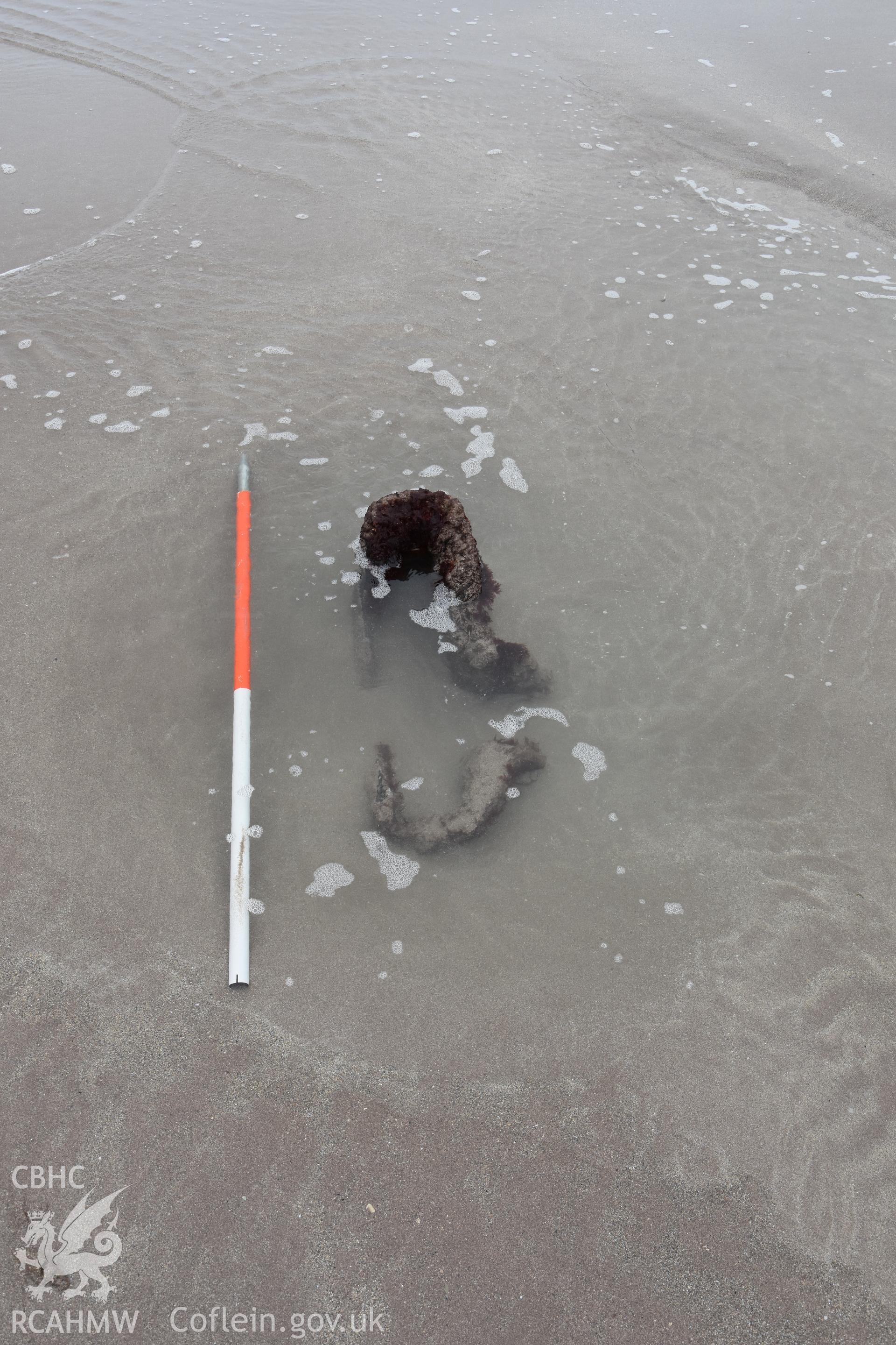 Part of the wreck exposed on the sand with 1m scale Taken by Daniel Hunt. Produced with EU funds through the Ireland Wales Co-operation Programme 2014-2023. All material made freely available through the Open Government Licence.
