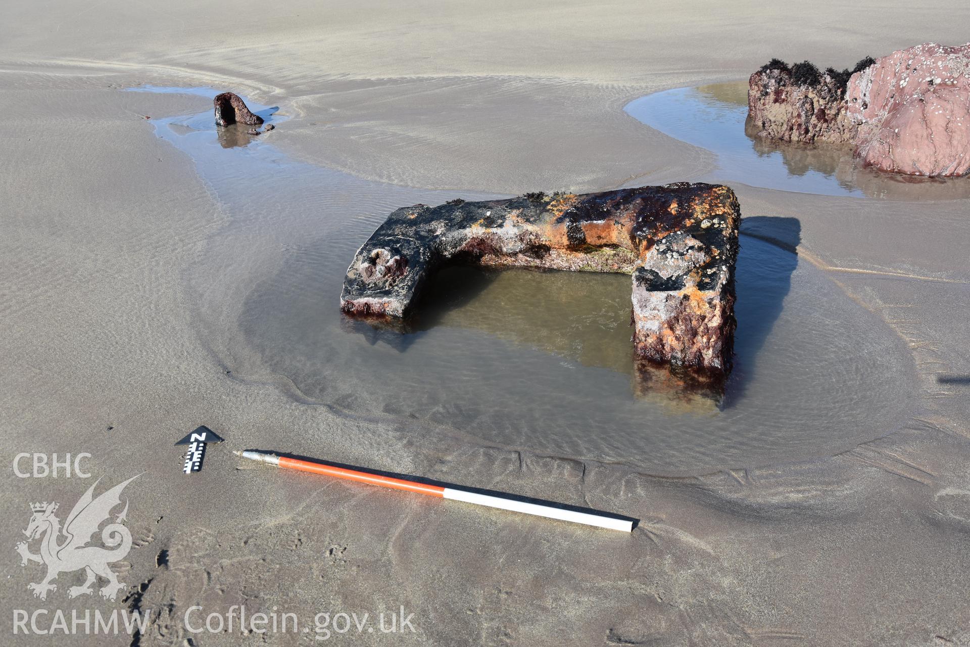 Element of the wreck exposed on the sand with 1m scale Taken by Daniel Hunt. Produced with EU funds through the Ireland Wales Co-operation Programme 2014-2023. All material made freely available through the Open Government Licence.
