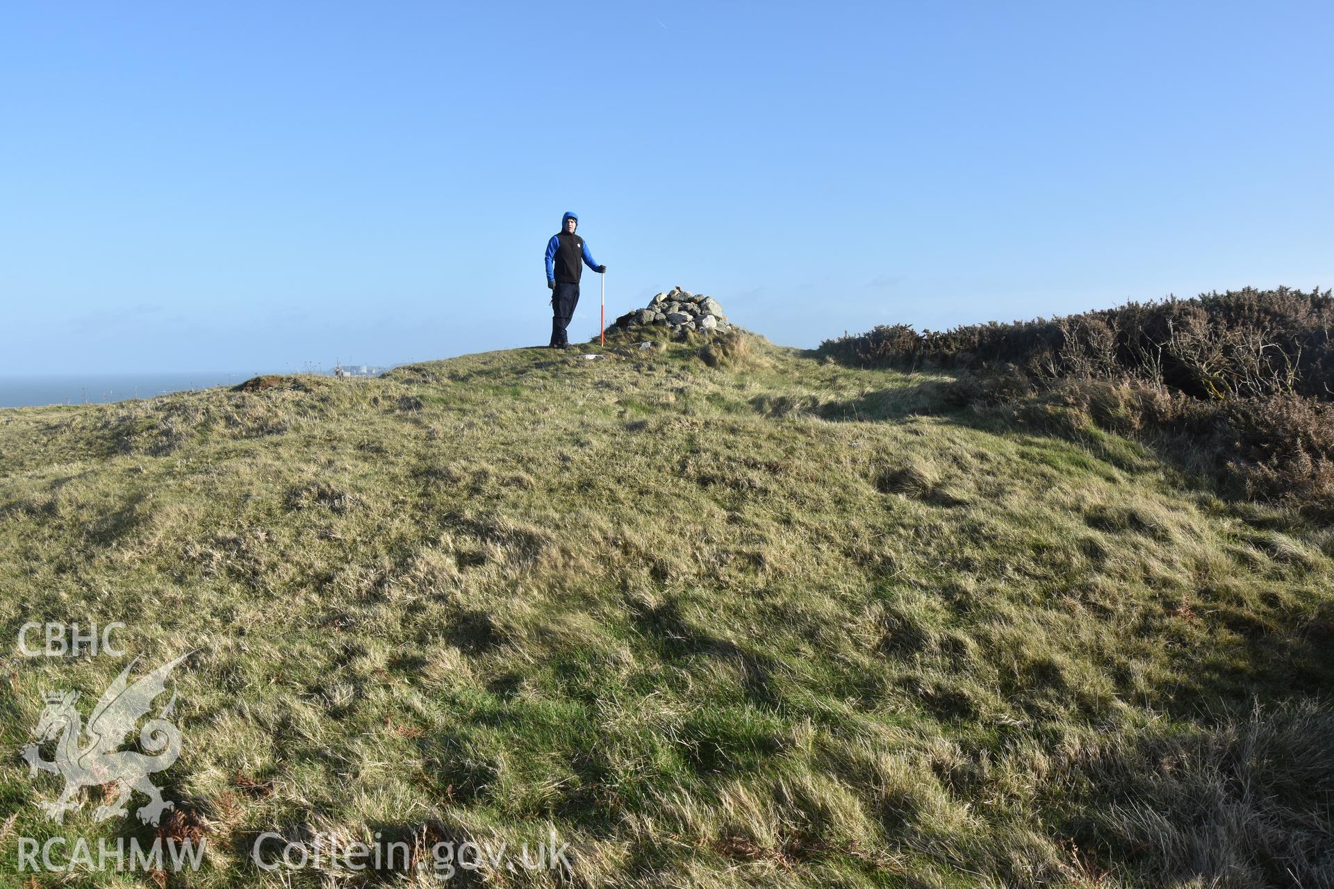 Pen Bryn yr Eglwys with figure and 2m scale. Taken by Lou Barker. Produced with EU funds through the Ireland Wales Co-operation Programme 2014-2023. All material made freely available through the Open Government Licence.