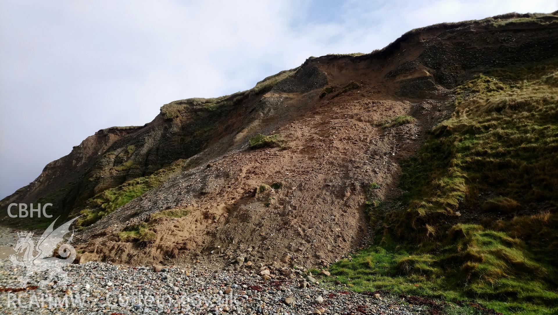 Eroding cliff face with patches of fallen turf. Camera facing NE. Taken by Toby Driver. Produced with EU funds through the Ireland Wales Co-operation Programme 2014-2023. All material made freely available through the Open Government Licence.