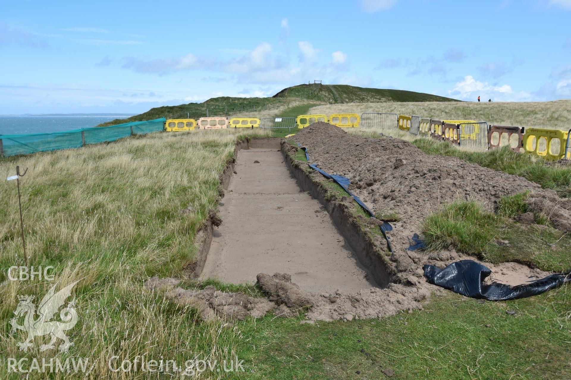 Open trench parallel to eroding cliff edge, showing layer of sand. Taken by Toby Driver. Produced with EU funds through the Ireland Wales Co-operation Programme 2014-2023. All material made freely available through the Open Government Licence.