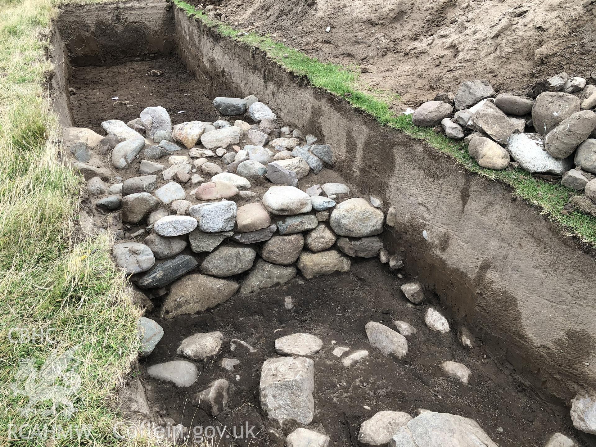 Roundhouse wall partially excavated in trench Taken by Toby Driver. Produced with EU funds through the Ireland Wales Co-operation Programme 2014-2023. All material made freely available through the Open Government Licence.