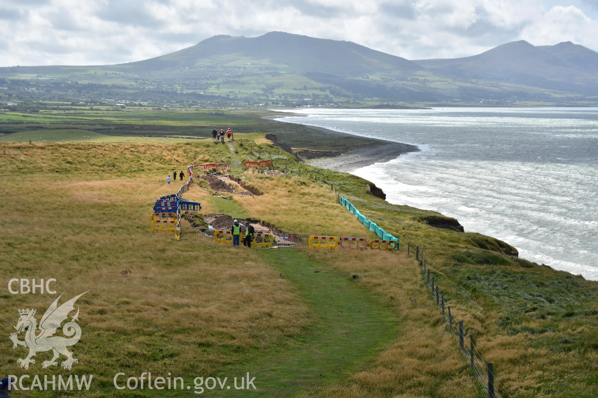 View south showing hillfort and open trench with archaeologists supervising preparations for hand excavation. Taken by Toby Driver. Produced with EU funds through the Ireland Wales Co-operation Programme 2014-2023. All material made freely available throu