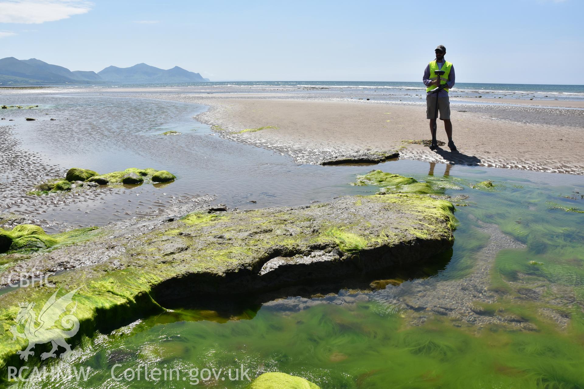 Member of the CHERISH team surveying on the beach at Dinas Dinlle. Photograph taken in June 2018 as part of repeat monitoring and survey by the CHERISH project. © Crown: CHERISH PROJECT 2018 Produced with EU funds through the Ireland Wales Co-operation Programme 2014-2023. All material made freely available through the Open Government Licence.