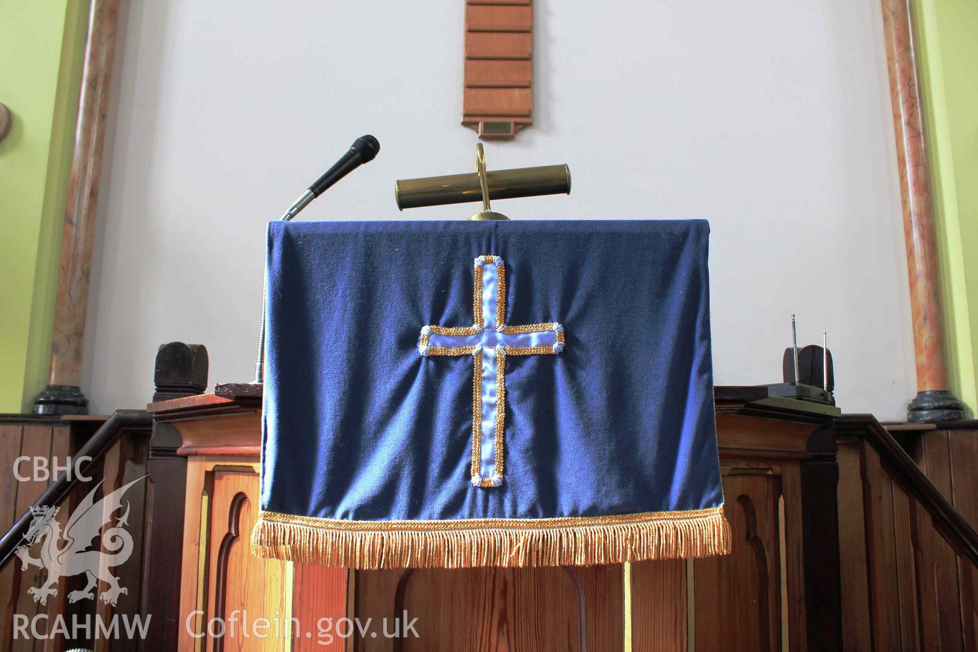 Blue parament on pulpit with cross.