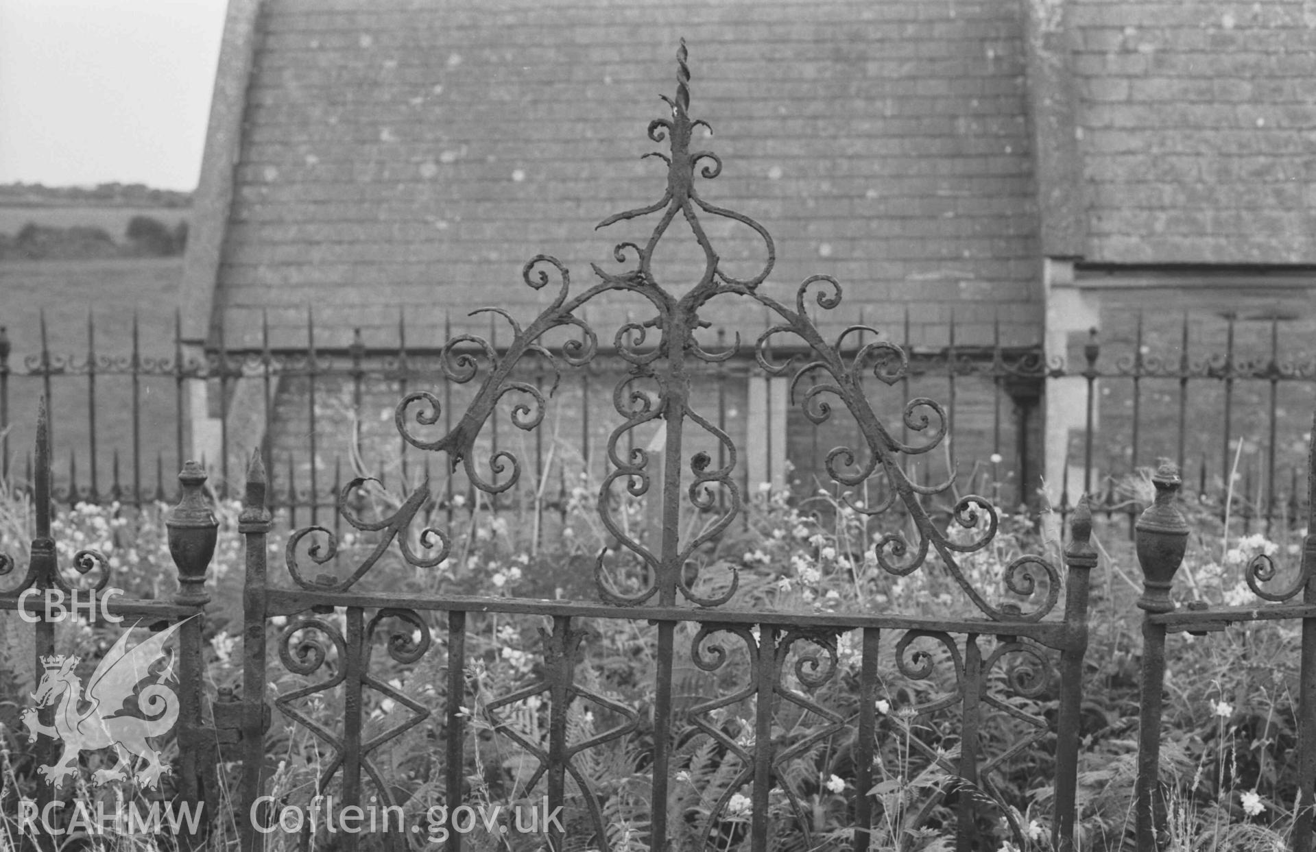 Digital copy of a black and white negative showing detailed view of top of wrought iron gate to grave enclosure of the Evans family, c. 1850, to the north of the chancel at St Pedrog's Church. Photographed by Arthur Chater on 30 August 1968. Looking south from Grid Reference SN 183 496.