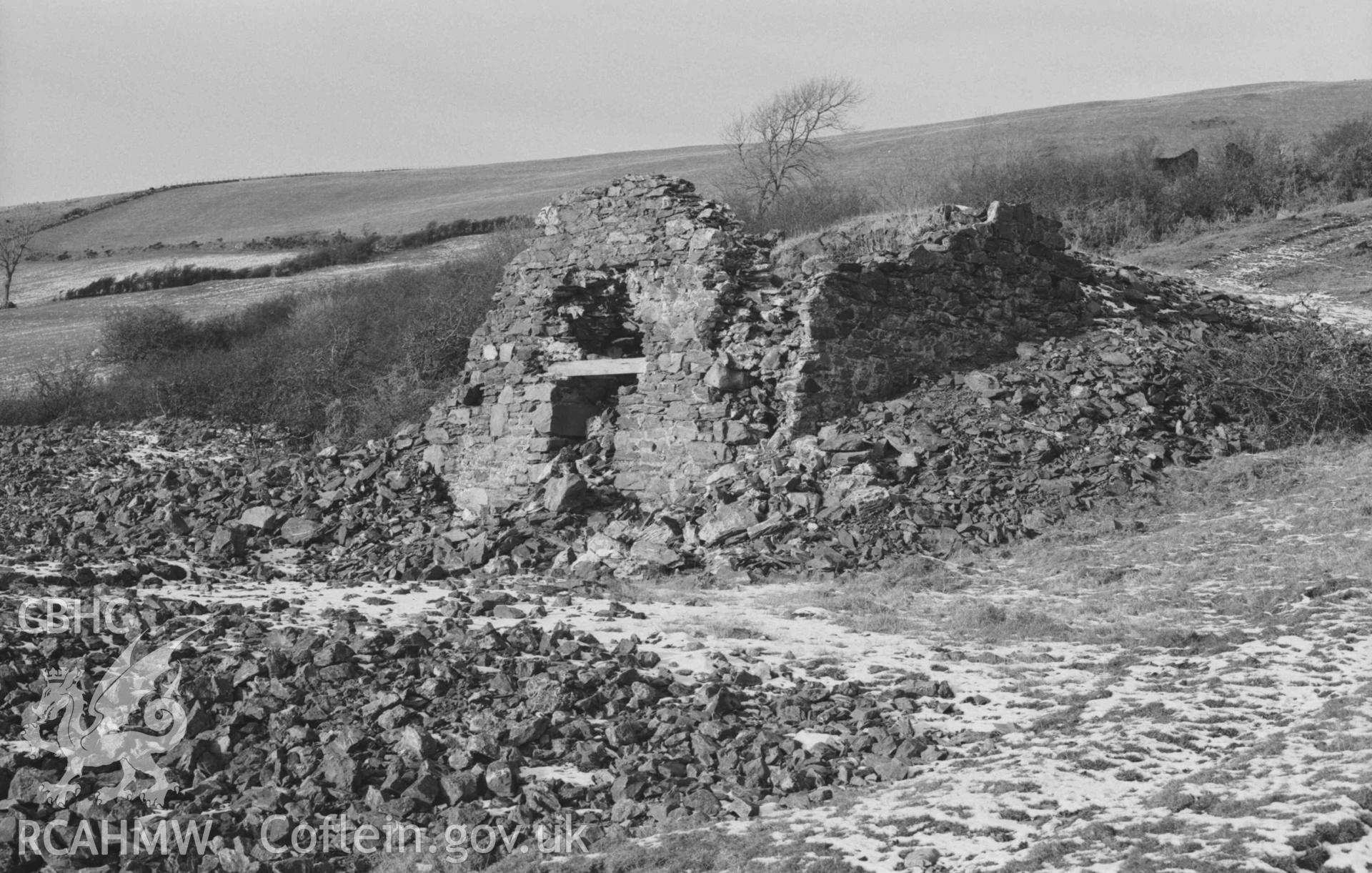 Digital copy of a black and white negative showing ruin 75m south south west of Mine Cottage, Mynydd-Gorddu mine, with large stone-lined furnace at the back. Photographed by Arthur Chater on 29 December 1968. Looking north west from Grid Reference SN 6676 8602.
