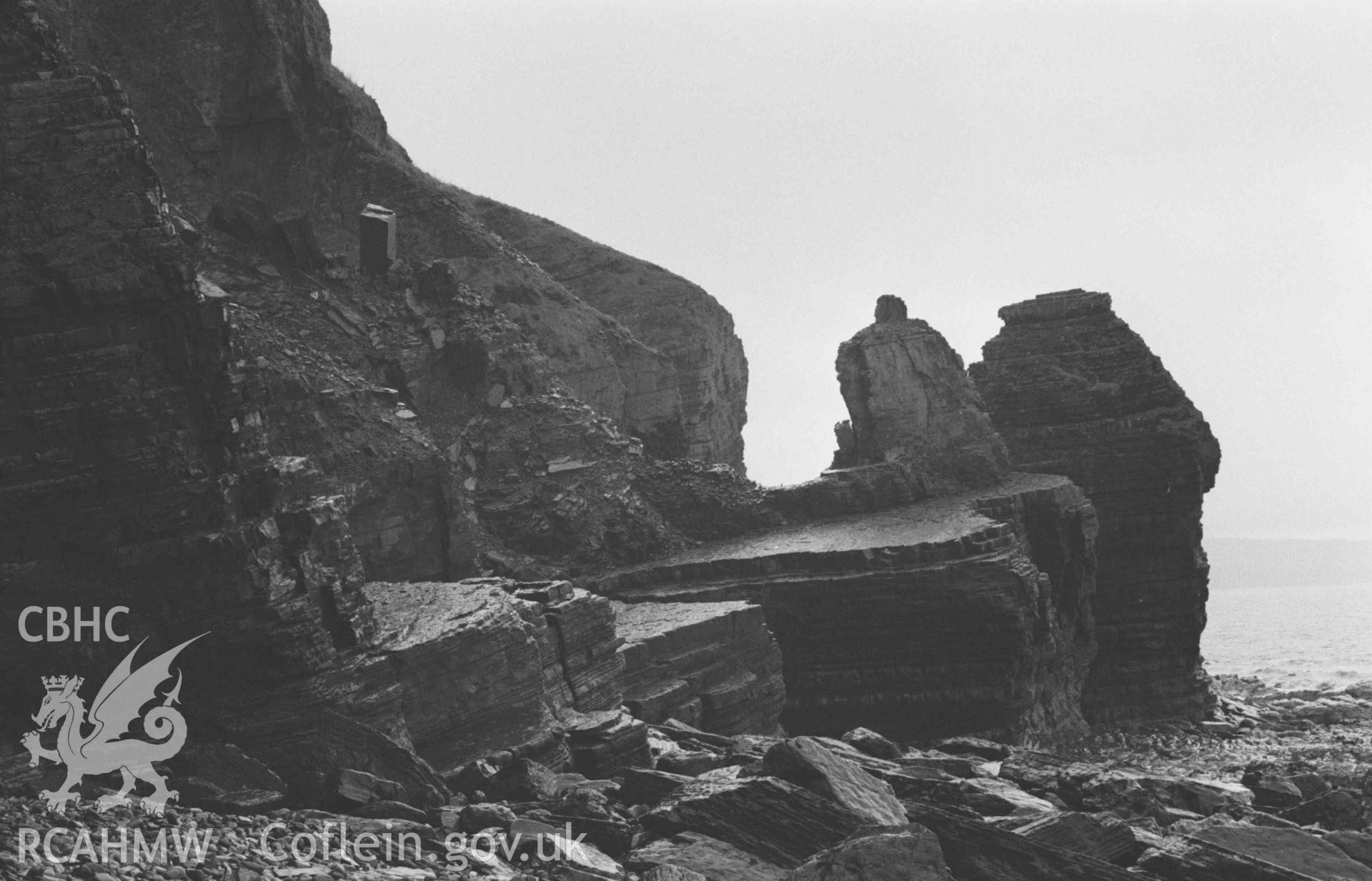 Digital copy of a black and white negative showing rocks on the coast 350m west south west of the mouth of the afon Cwinten, at low tide. Photographed by Arthur Chater on 3 January 1969. Looking west from Grid Reference SN 4322 6123.