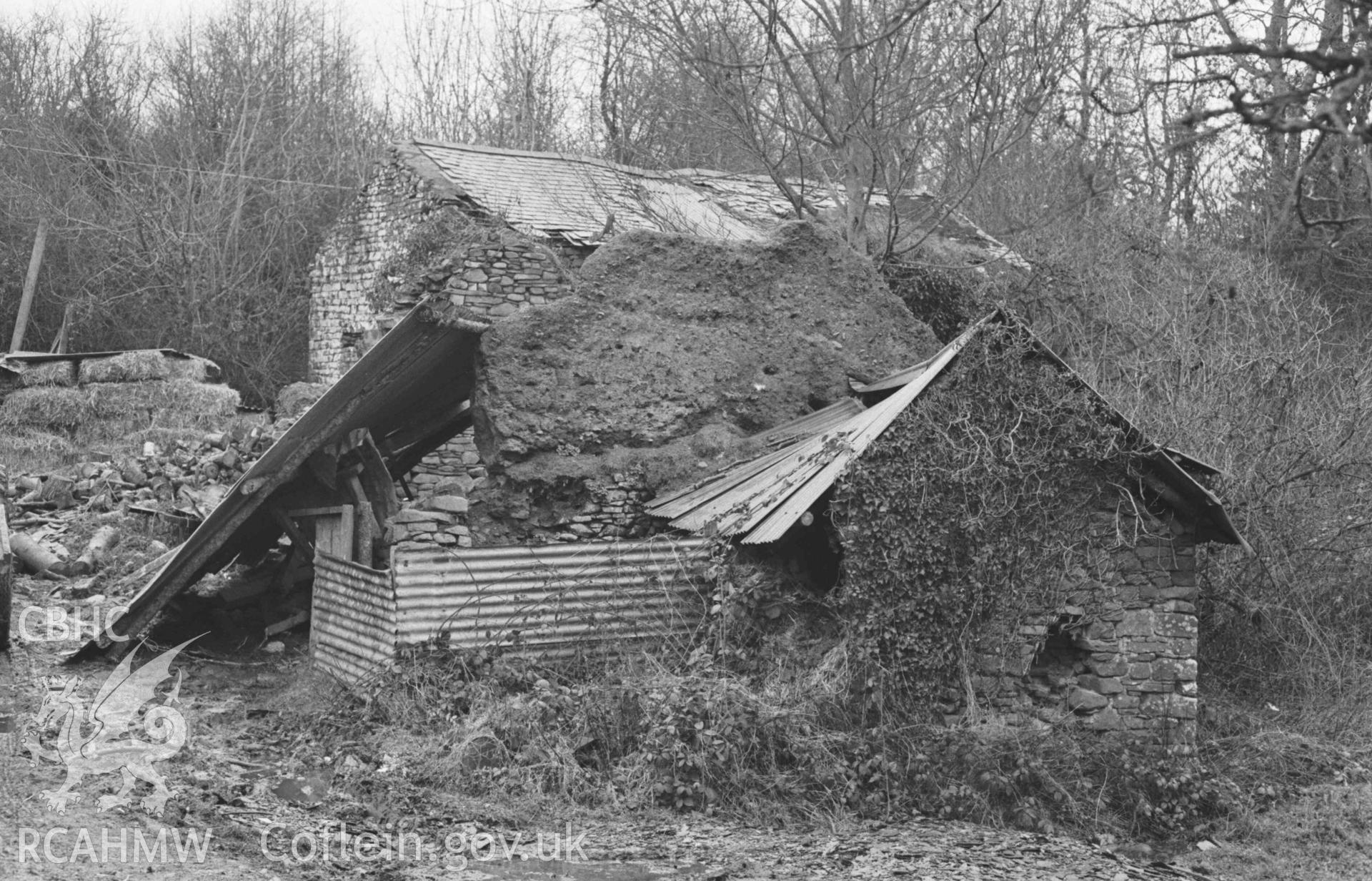 Digital copy of a black and white negative showing ruined mud and stone buildings on the south east side of the lane and north of Afon Drywi at Felin Fach, 750m north west of Oakford. Photographed by Arthur Chater on 3 January 1969. Looking north east from Grid Reference SN 4454 5847.