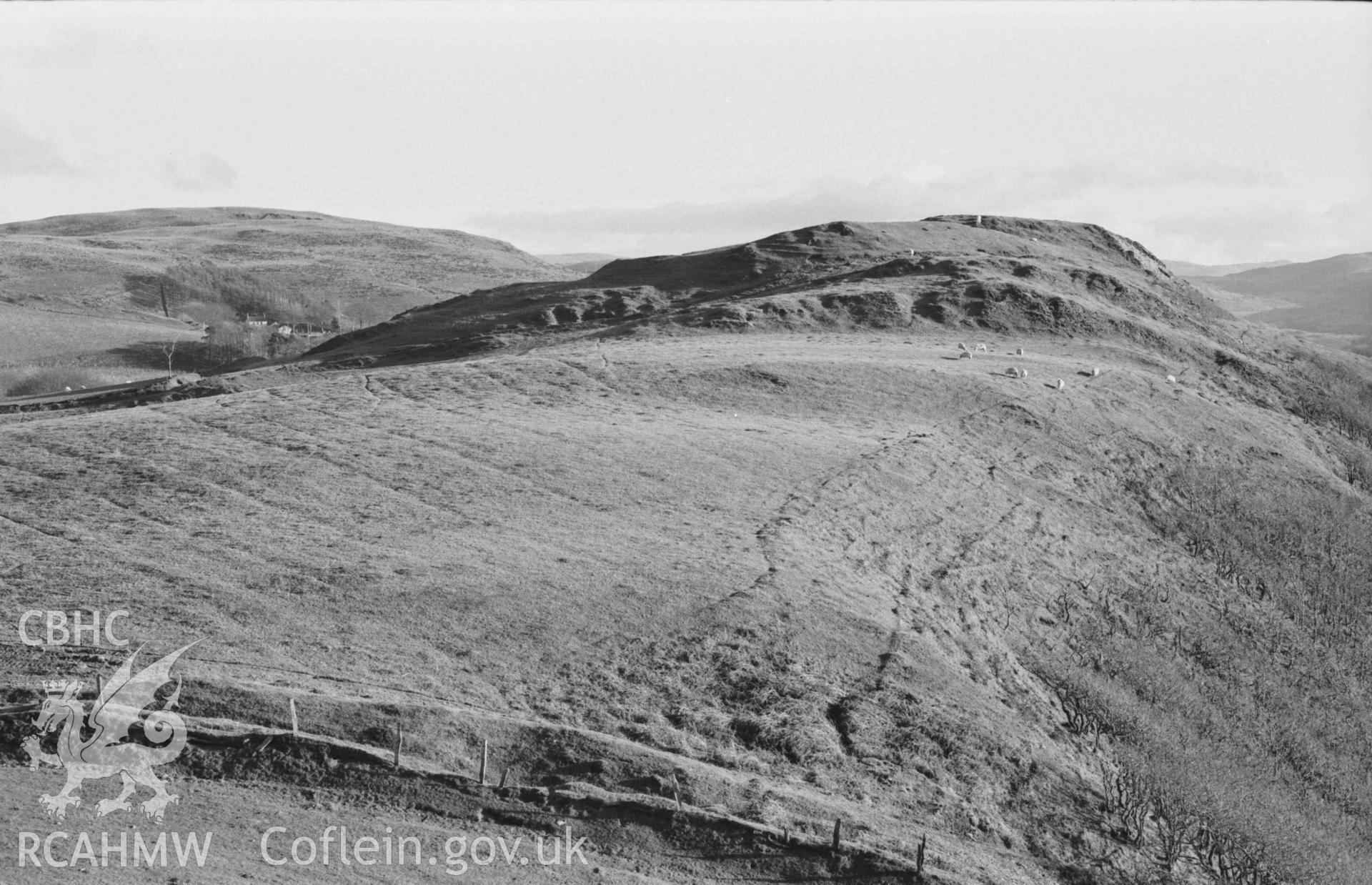 Digital copy of a black and white negative showing Castell Bwa Drain iron age camp. Photographed by Arthur Chater on 5 January 1969. Looking south east from Grid Reference SN 7105 7963.