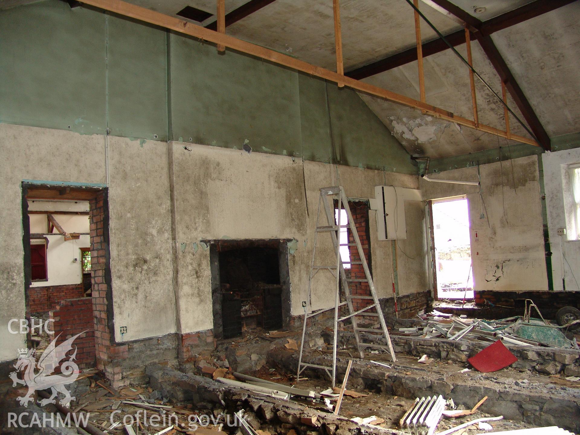 Photograph from a building recording survey: Zion Chapel, High Street, Newbridge, Gwent; internal view, of vestry /store area showing side entry door, doorways into main chapel and central fireplace. Carried out by A. P. A. C. Ltd. in September 2008.