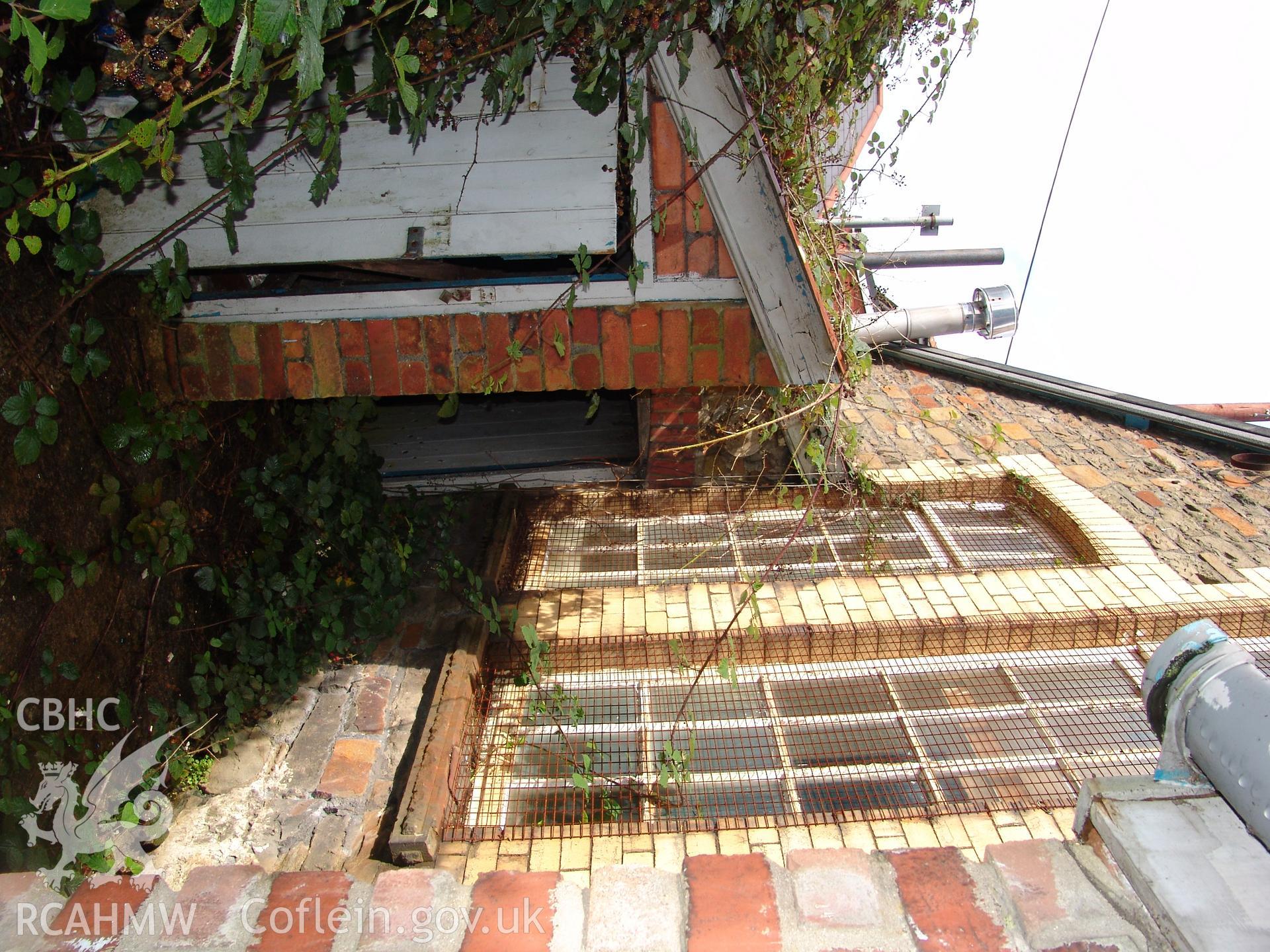 Photograph from a building recording survey: Zion Chapel, High Street, Newbridge, Gwent; rear of building with boiler house door. Carried out by A. P. A. C. Ltd. in September 2008.