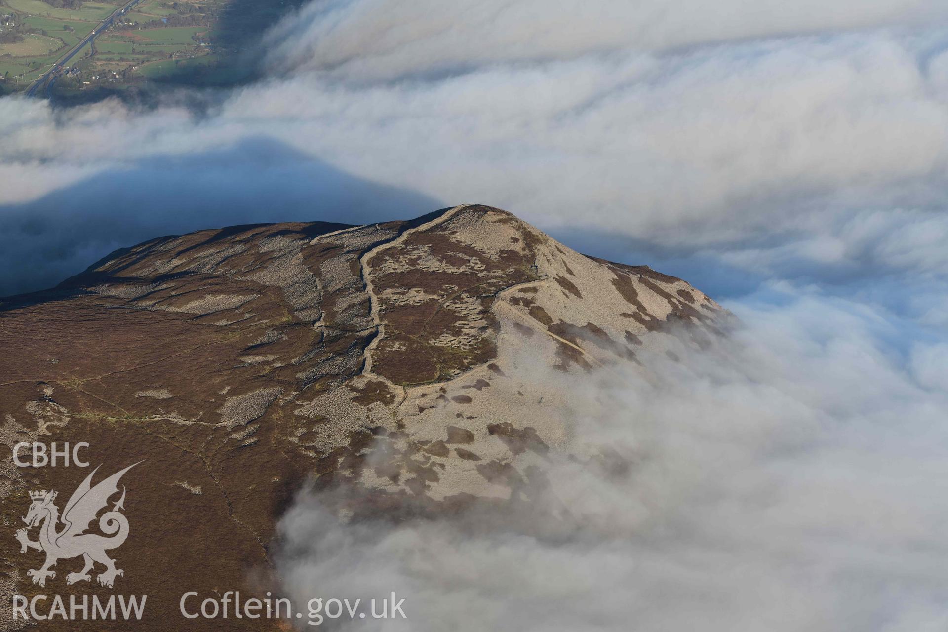 Oblique aerial photograph of Tre'r Ceiri, with cloud inversion, taken during the Royal Commission