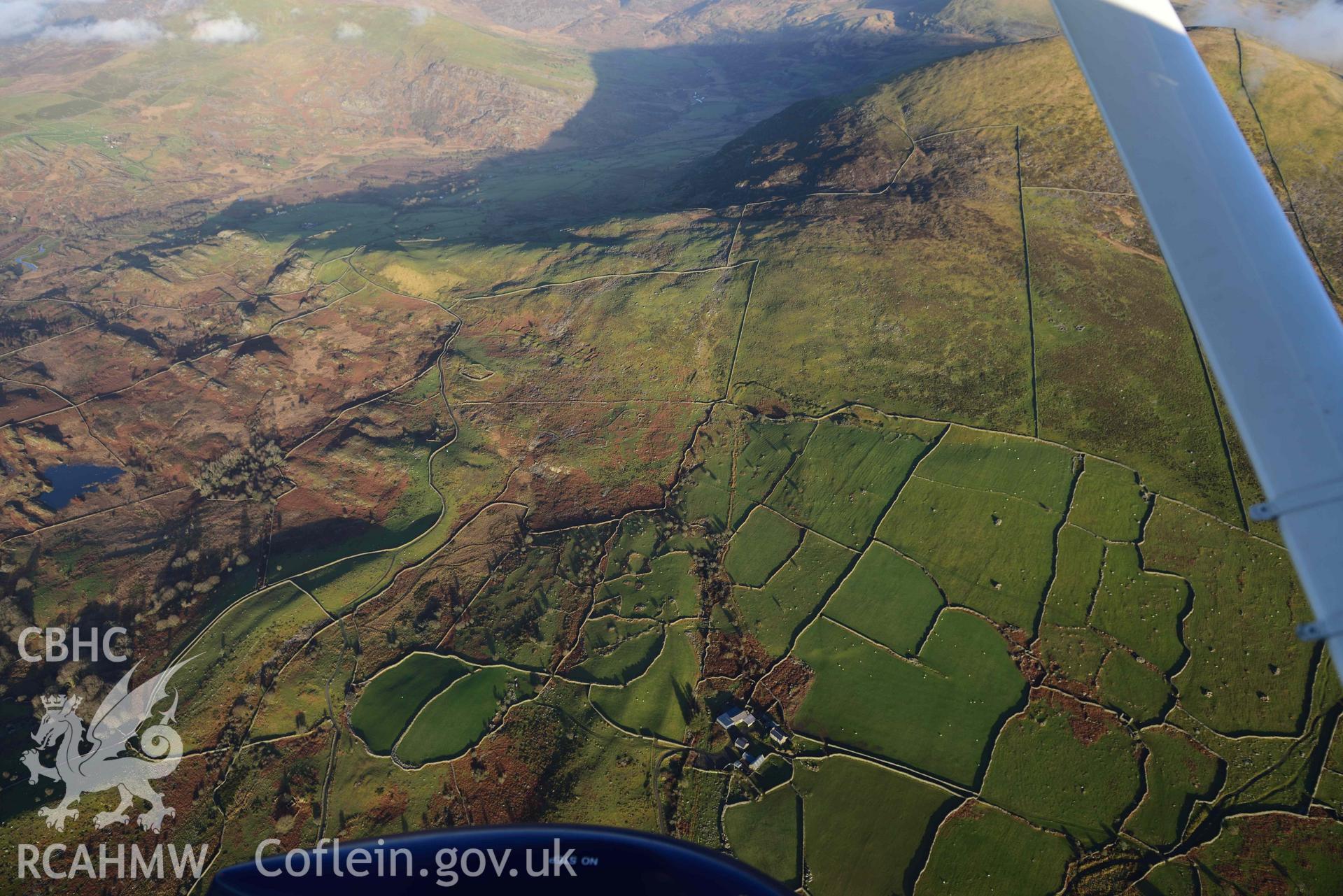 Oblique aerial photograph of Bron y Foel hut group taken during the Royal Commission