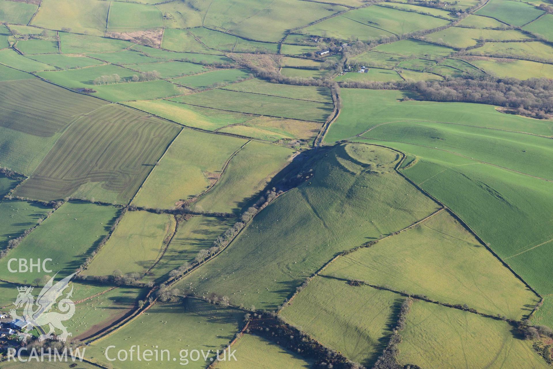 Oblique aerial photograph of Castell Perthi Mawr, with earthworks of prehistoric fields to the north west. Taken during the Royal Commission’s programme of archaeological aerial reconnaissance by Toby Driver on 17th January 2022