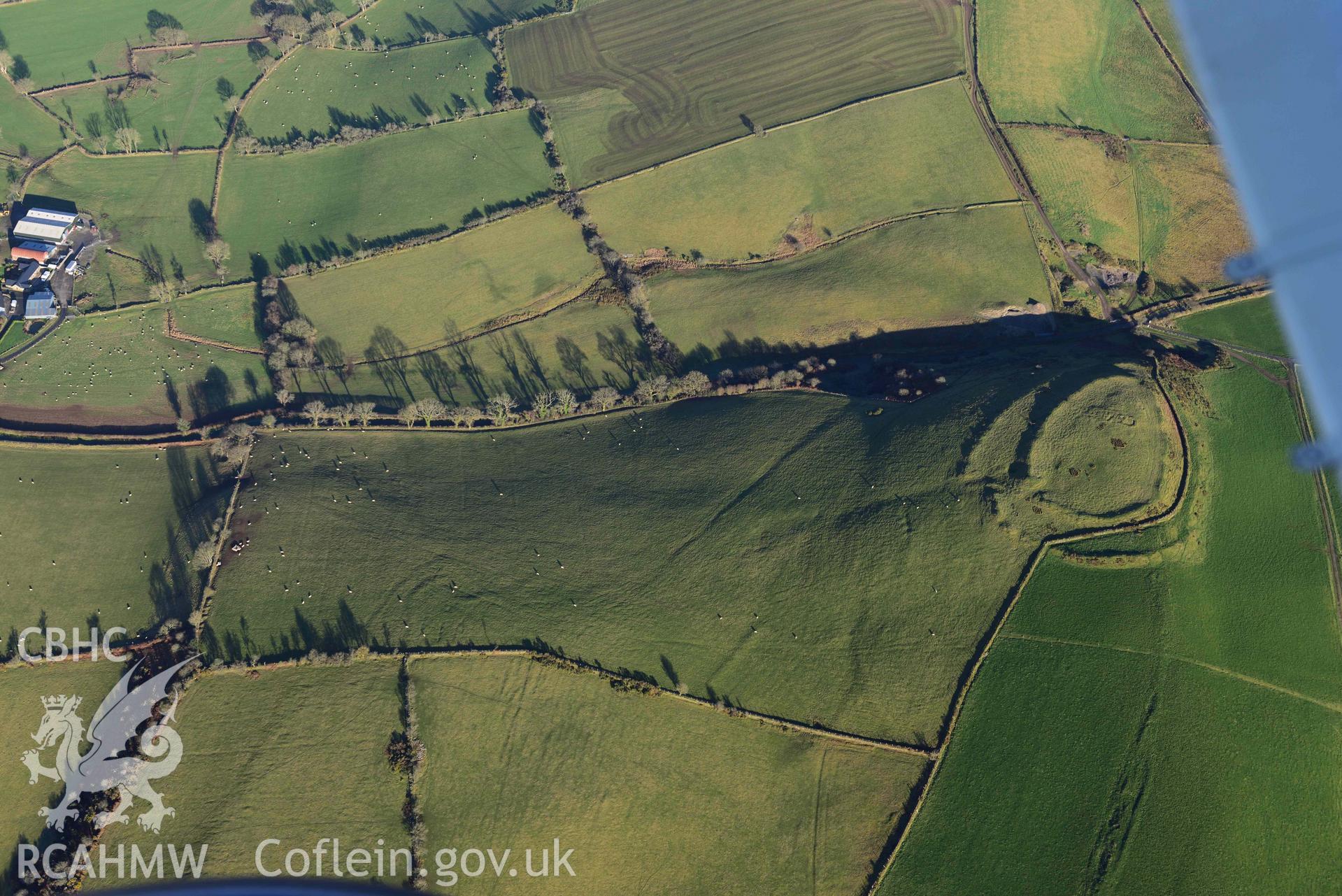 Oblique aerial photograph of Castell Perthi Mawr, with earthworks of prehistoric fields to the north west. Taken during the Royal Commission’s programme of archaeological aerial reconnaissance by Toby Driver on 17th January 2022