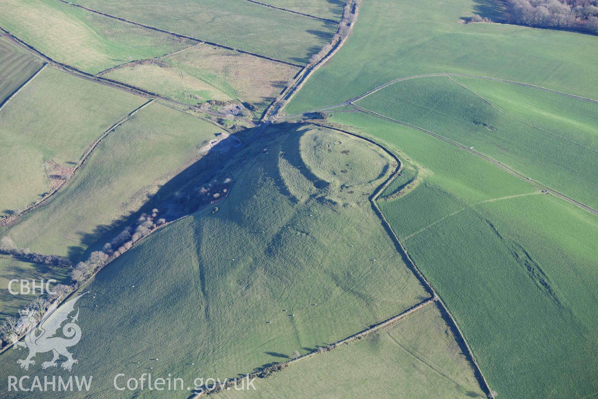 Oblique aerial photograph of Castell Perthi Mawr, with earthworks of prehistoric fields to the north west. Taken during the Royal Commission’s programme of archaeological aerial reconnaissance by Toby Driver on 17th January 2022