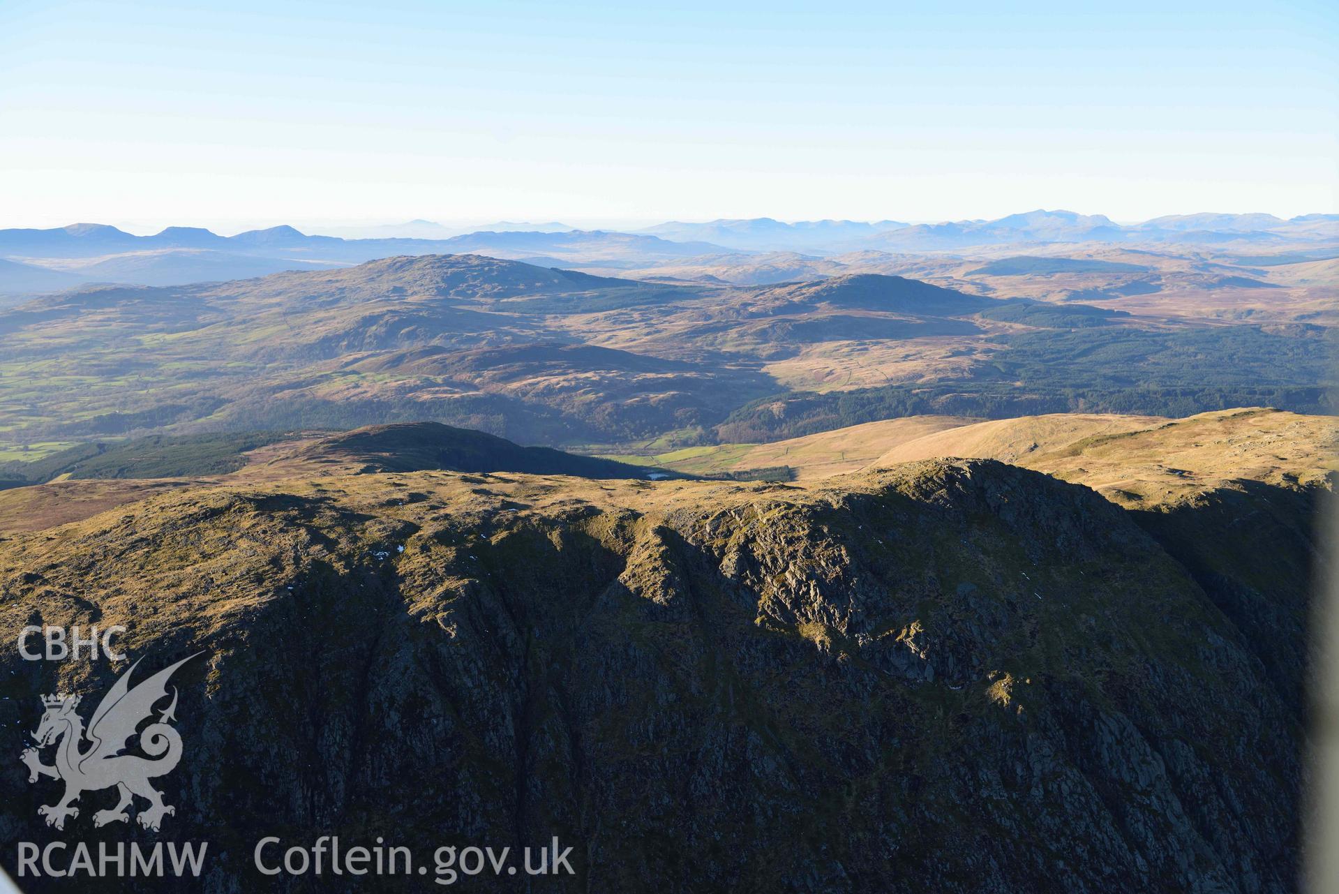 Oblique aerial photograph showing the winter mountain landscape of Aran Fawddwy, looking north west over the summit ridge. Taken during the Royal Commission’s programme of archaeological aerial reconnaissance by Toby Driver on 17th January 2022