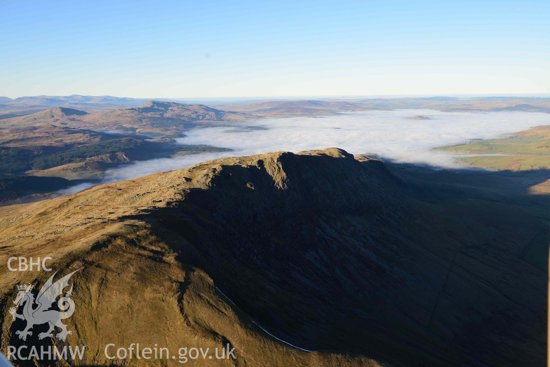Oblique aerial photograph showing view looking north of Aran Fawddwy with Bala cloud inversion. Taken during the Royal Commission’s programme of archaeological aerial reconnaissance by Toby Driver on 17th January 2022