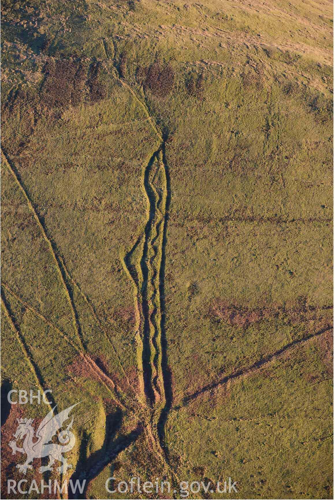 Oblique aerial photograph of Mynydd Fron-fraith zig-zag peat sledway and landscape taken conducted during the Royal Commission’s programme of archaeological aerial reconnaissance by Toby Driver on 17th January 2022