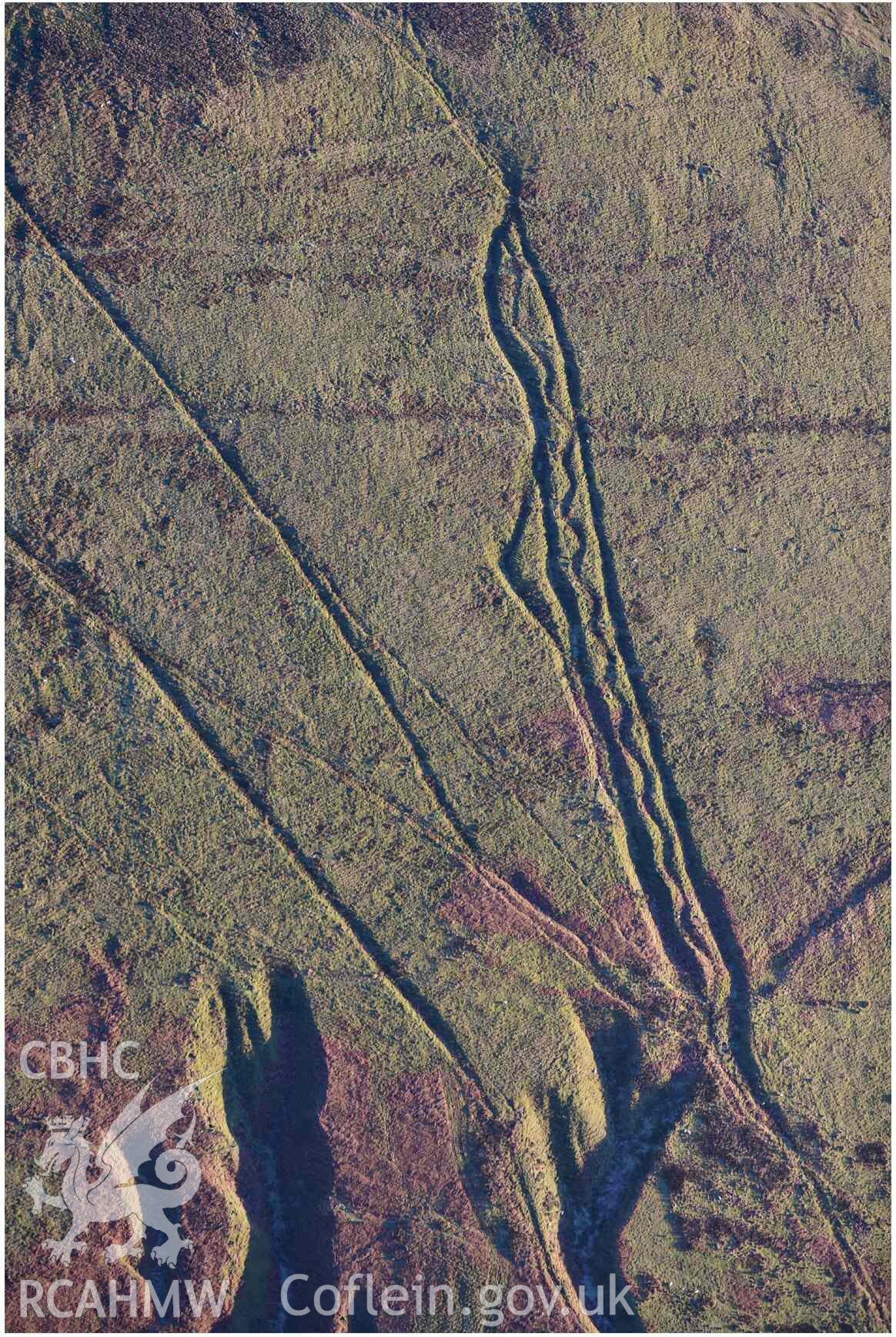 Oblique aerial photograph of Mynydd Fron-fraith zig-zag peat sledway and landscape taken conducted during the Royal Commission’s programme of archaeological aerial reconnaissance by Toby Driver on 17th January 2022