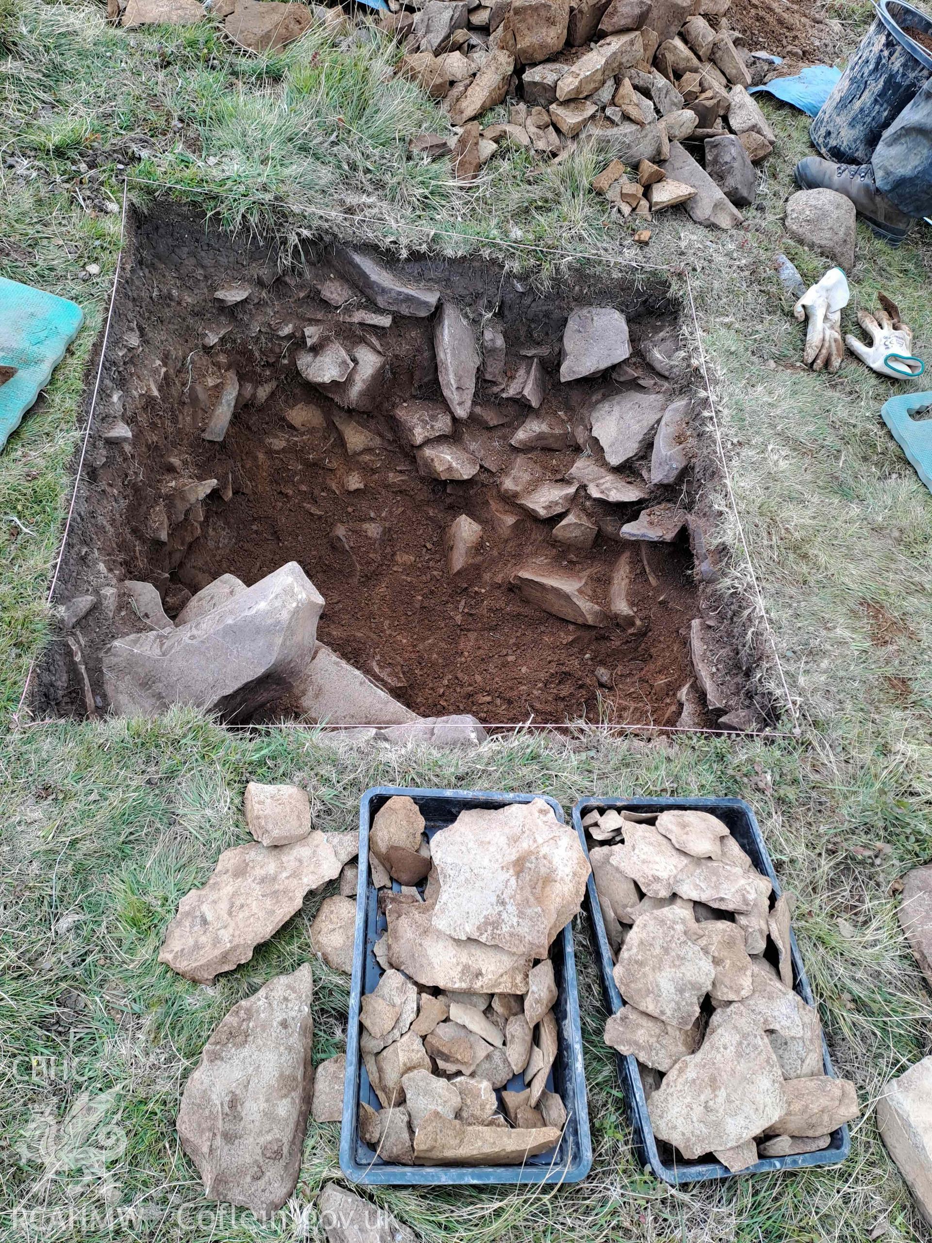 Image showing the excavation of test pits forming part of the Carneddau Scheme. The archaeological investigation, which has been undertaken with volunteers, is a collaboration between the Eryri National Park’s Carneddau Scheme, funded by the National Lottery Heritage Fund, and Gwynedd Archaeological Trust, funded by Cadw. It aims to identify the extent of the Neolithic axe-working landscape about Penmaenmawr and Llanfairfechan. The workings were previously thought to be focussed only on the area of Graiglwyd axe factory.