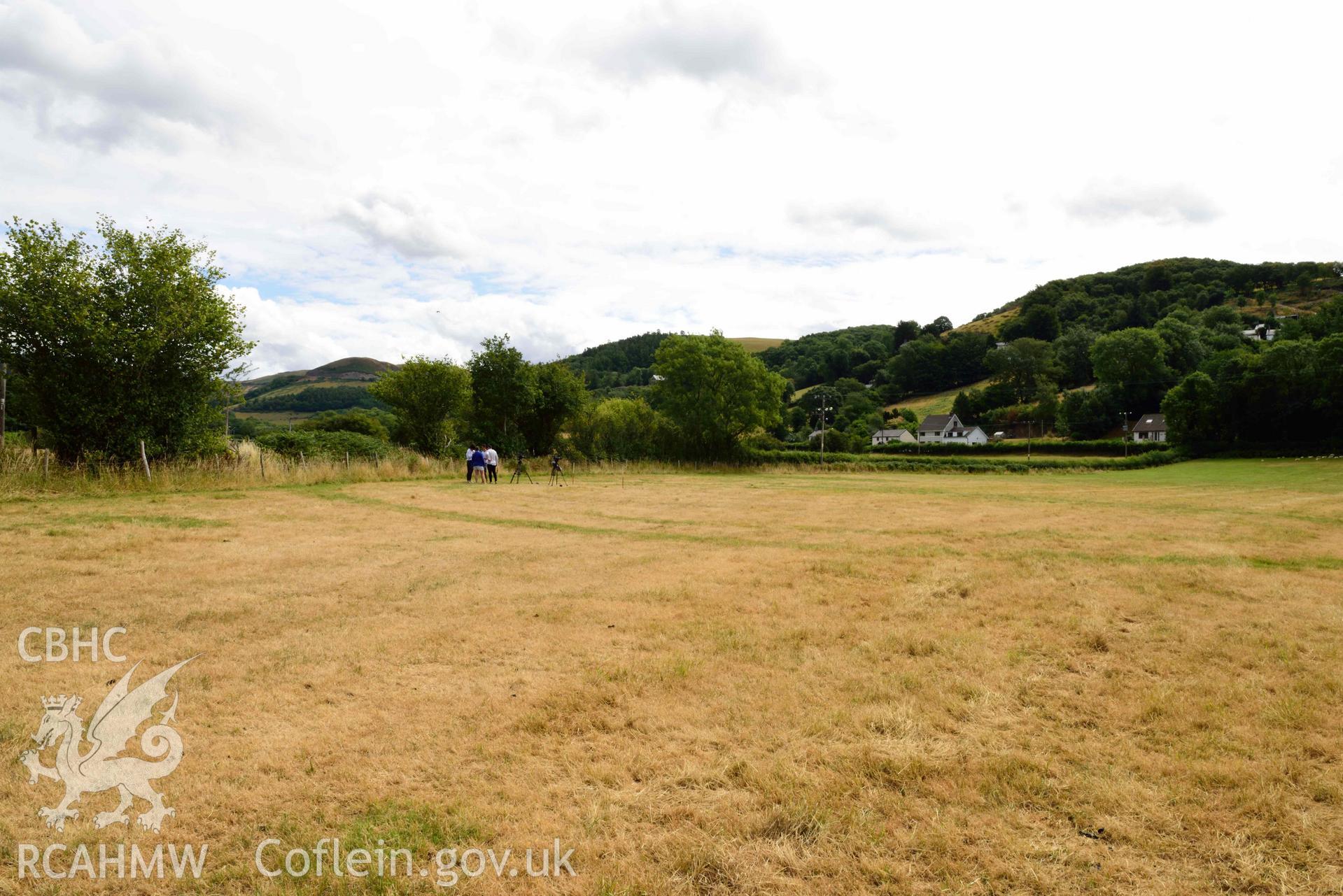 View of cropmarked barrow from north-west at Dollwen barrow cemetery. Photographed by Toby Driver of RCHMAW during BBC filming of The One Show, 17 July 2018. Associated with Geophysical Survey of Pen y Wal, Dollwen Barrow, Goginan, commissioned by the RCAHMW and produced by Sumo Survey, 2021.