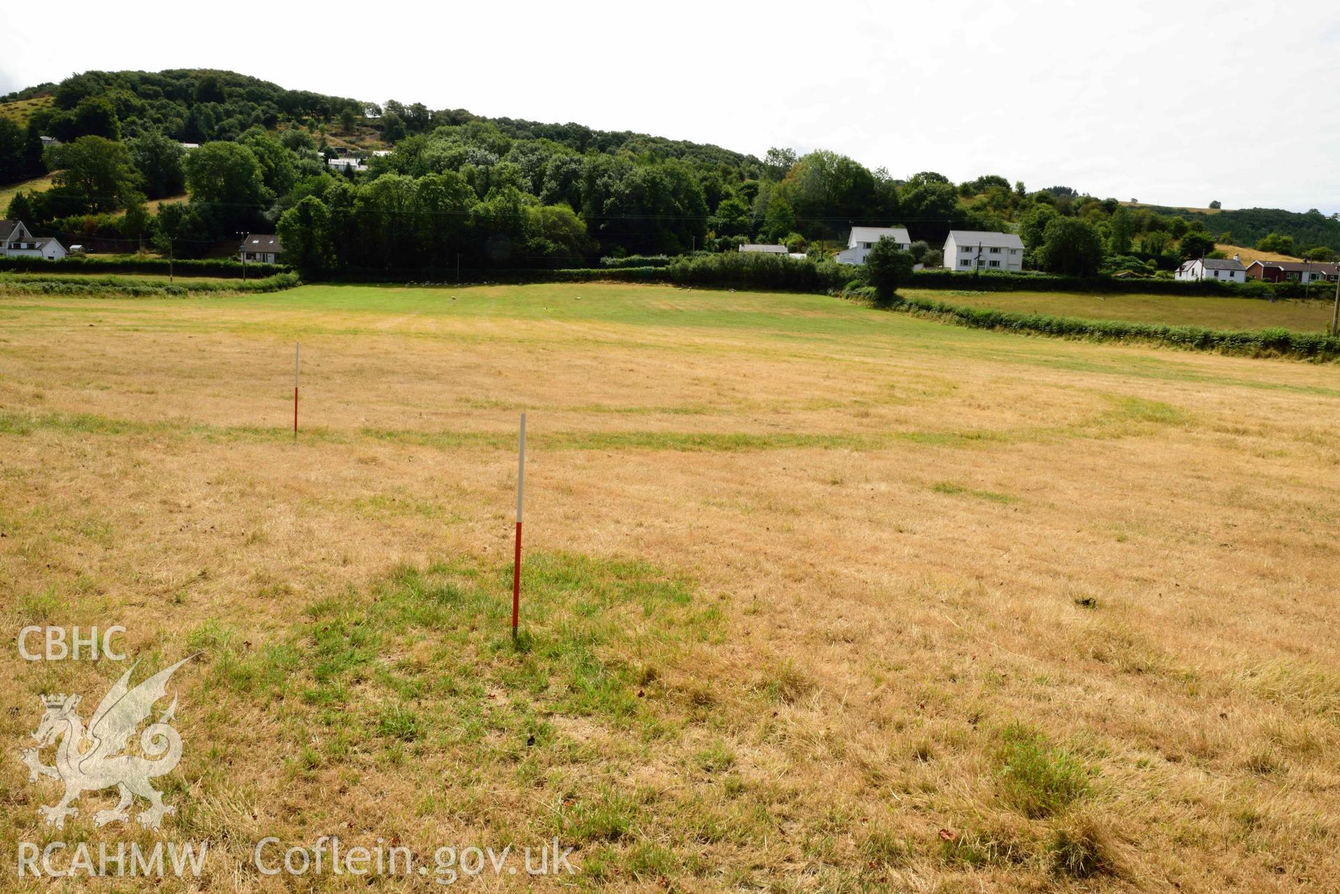 View of pit or post/stone hole to north-west of concentric barrow at SN 6868 8146, looking south (scale 1m) at Dollwen barrow cemetery. Photographed by Toby Driver of RCHMAW during BBC filming of The One Show, 17 July 2018. Associated with Geophysical Survey of Pen y Wal, Dollwen Barrow, Goginan, commissioned by the RCAHMW and produced by Sumo Survey, 2021.