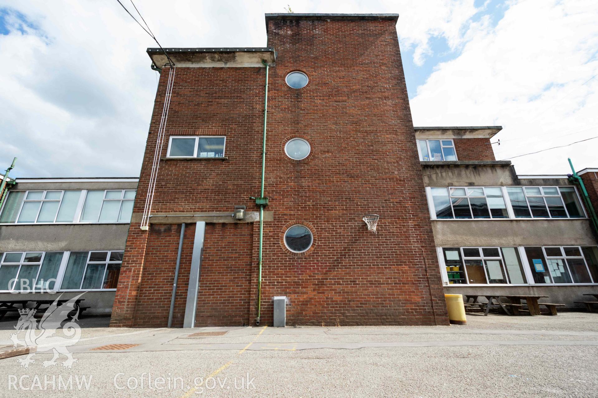 Low angle of D&T block north west side. Brick exterior of protruding staircase with round windows. Looking south east. Cathays High School