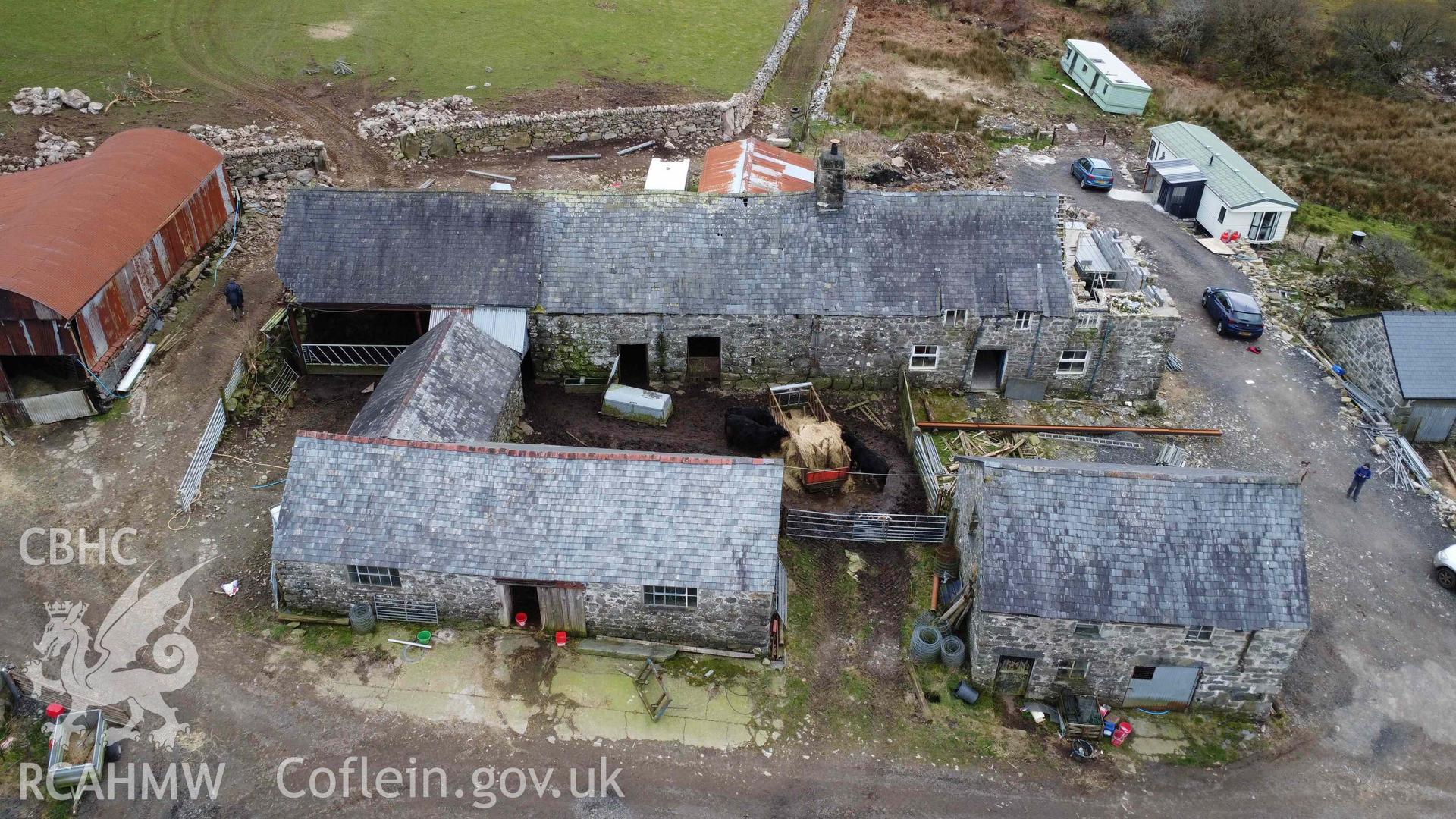 Aerial view of Tyddyn Mawr farmhouse and outbuildings looking south. Part of a photographic survey of Tyddyn Mawr farmhouse, Trawsfynydd, conducted by Dr Jayne Kamintzis of RCAHMW on 13 June 2023.
