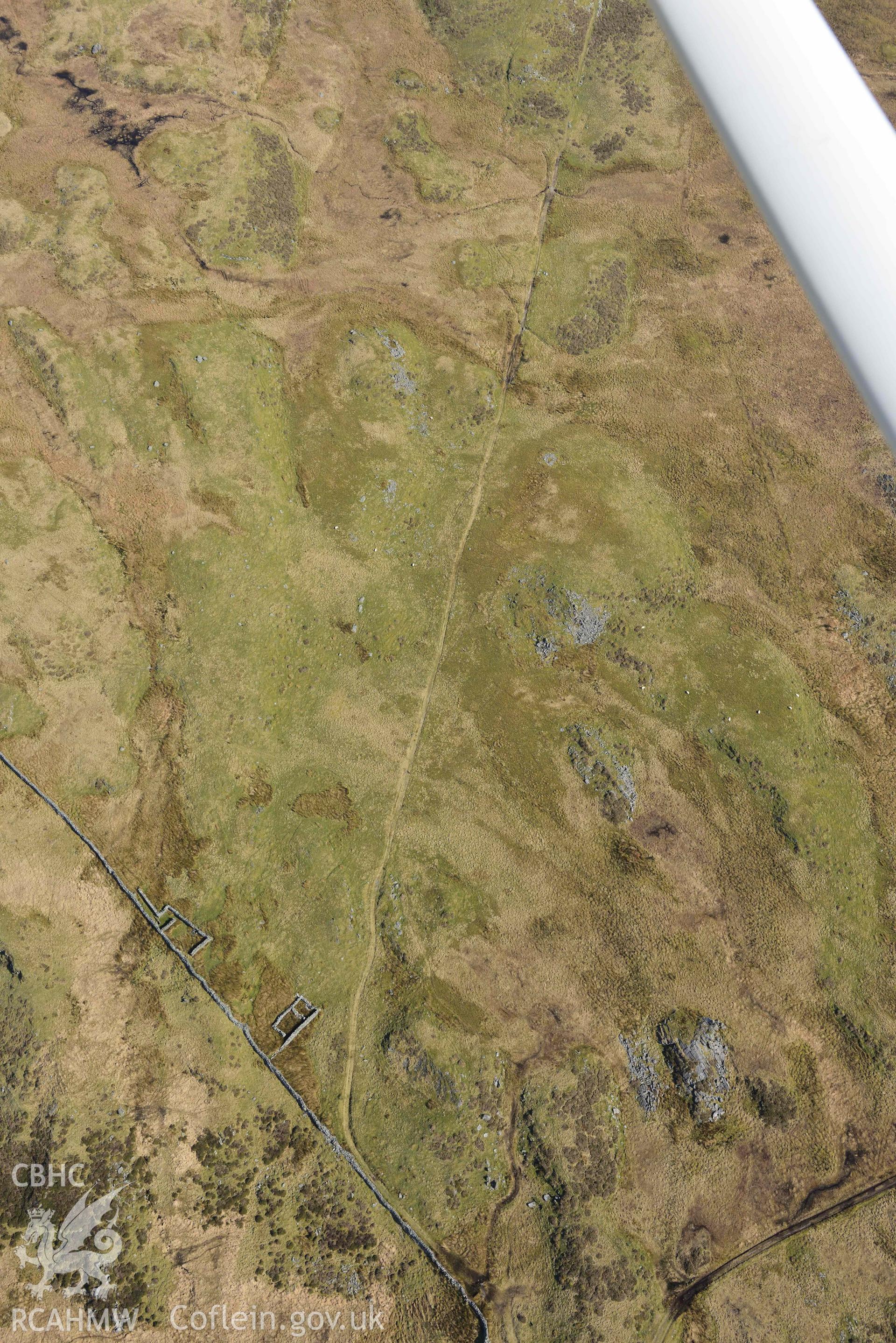 Hut Circle and Enclosure West of Llyn Eiddew Bach. Oblique aerial photographs taken during the Royal Commission’s programme of archaeological aerial reconnaissance by Toby Driver on 25 March 2022.