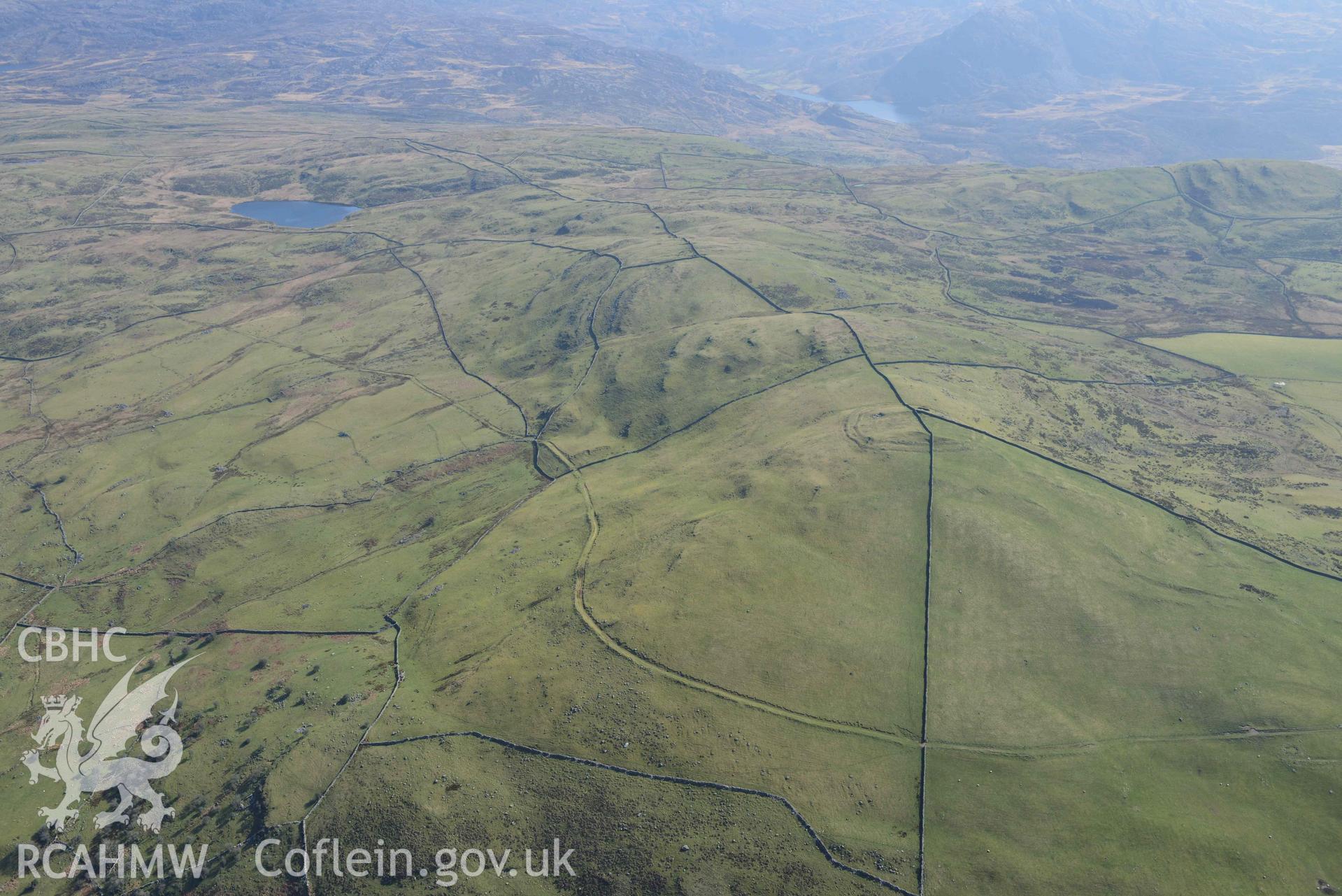 Moel Goedog hillfort, wide landscape view looking east. Oblique aerial photograph taken during the Royal Commission’s programme of archaeological aerial reconnaissance by Toby Driver on 25 March 2022.