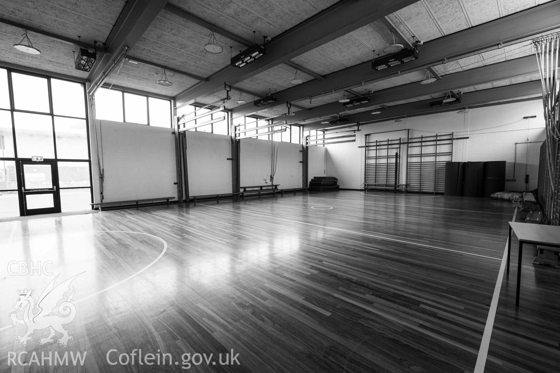 Gymnasium. View from entrance doors in corner. Black and white. Ysgol David Hughes