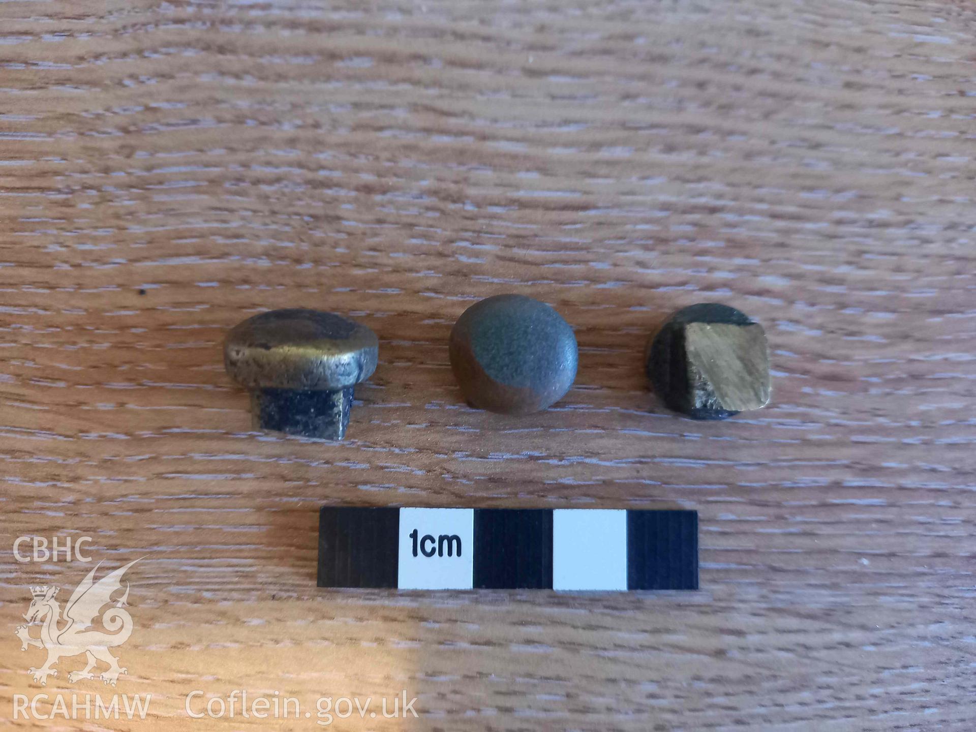 Yellow-metal nail heads from the port bow of Cefn Sidan wreck 3, sampled on 30/10/2023.