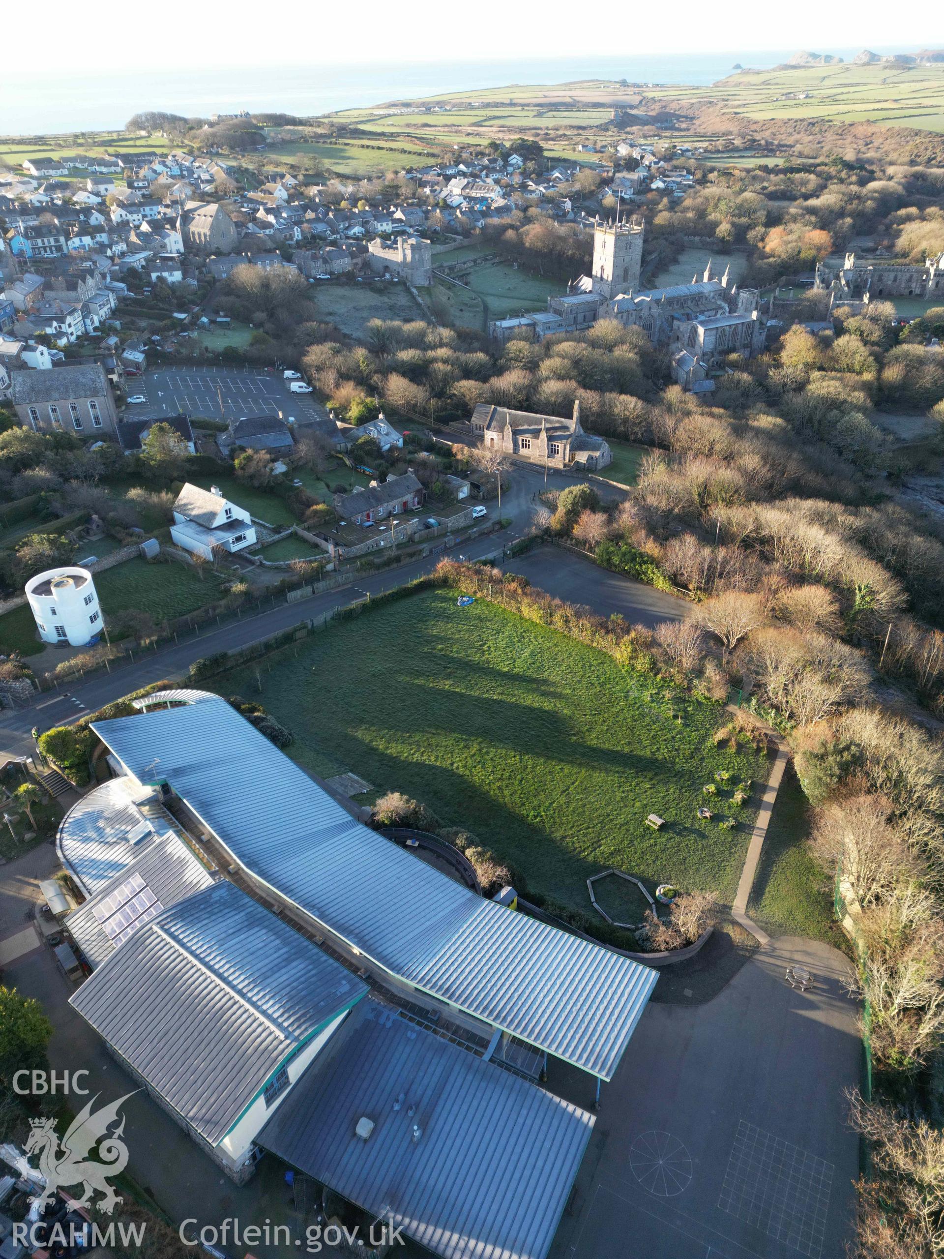 Oblique view, looking southwest on 1/12/2023, of Ysgol Bro Dewi (foreground), former site of St Davids County Primary (grassed area), and former St Davids VA School beyond. St Davids Cathedral is visible beyond the VA School.