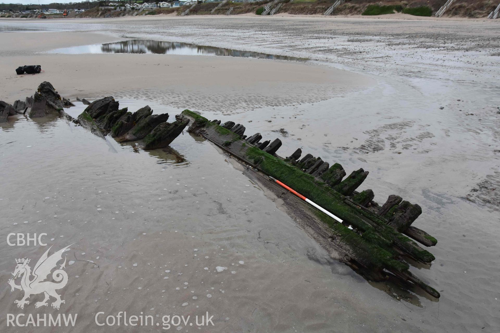 The wreck. Exposed frame and planking on the north side of vessel. Digital photograph of the Unnamed Wreck (Fosil?) on The Warren Beach, Abersoch, taken by Louise Barker on 23 January 2019. Crown Copyright. CHERISH project. Produced with EU funds through the Ireland Wales Co-operation Programme 2014-2023. All material made freely available through the Open Government Licence.