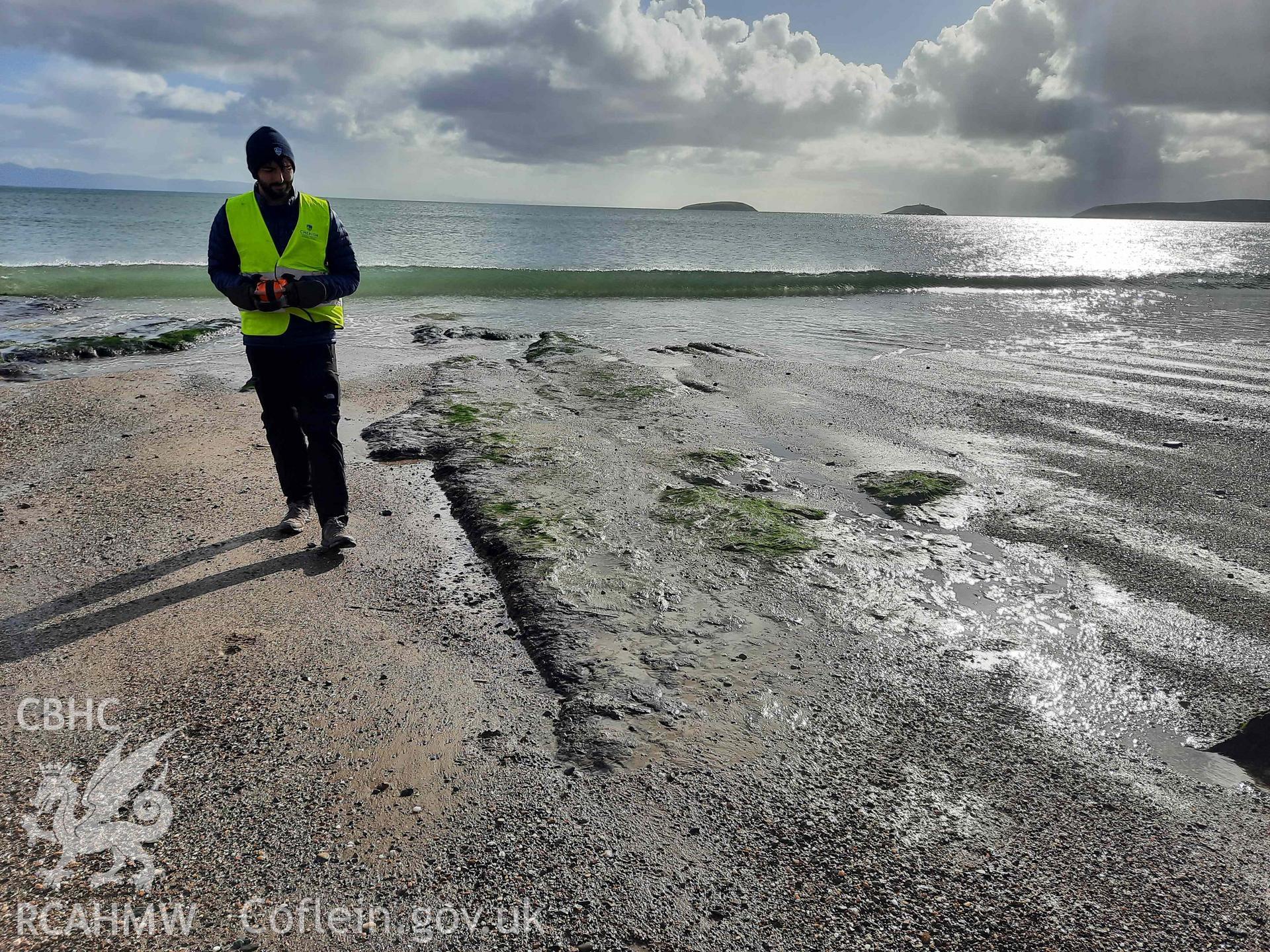 Peat exposure near low water mark. View looking southeast. Part of a survey of the Submerged Forest, Peat Exposures and Footprints on The Warren Beach, Abersoch, conducted by Louise Barker on 21 October 2021. Produced with EU funds through the Ireland Wales Co-operation Programme 2014-2023. All material made freely available through the Open Government Licence.