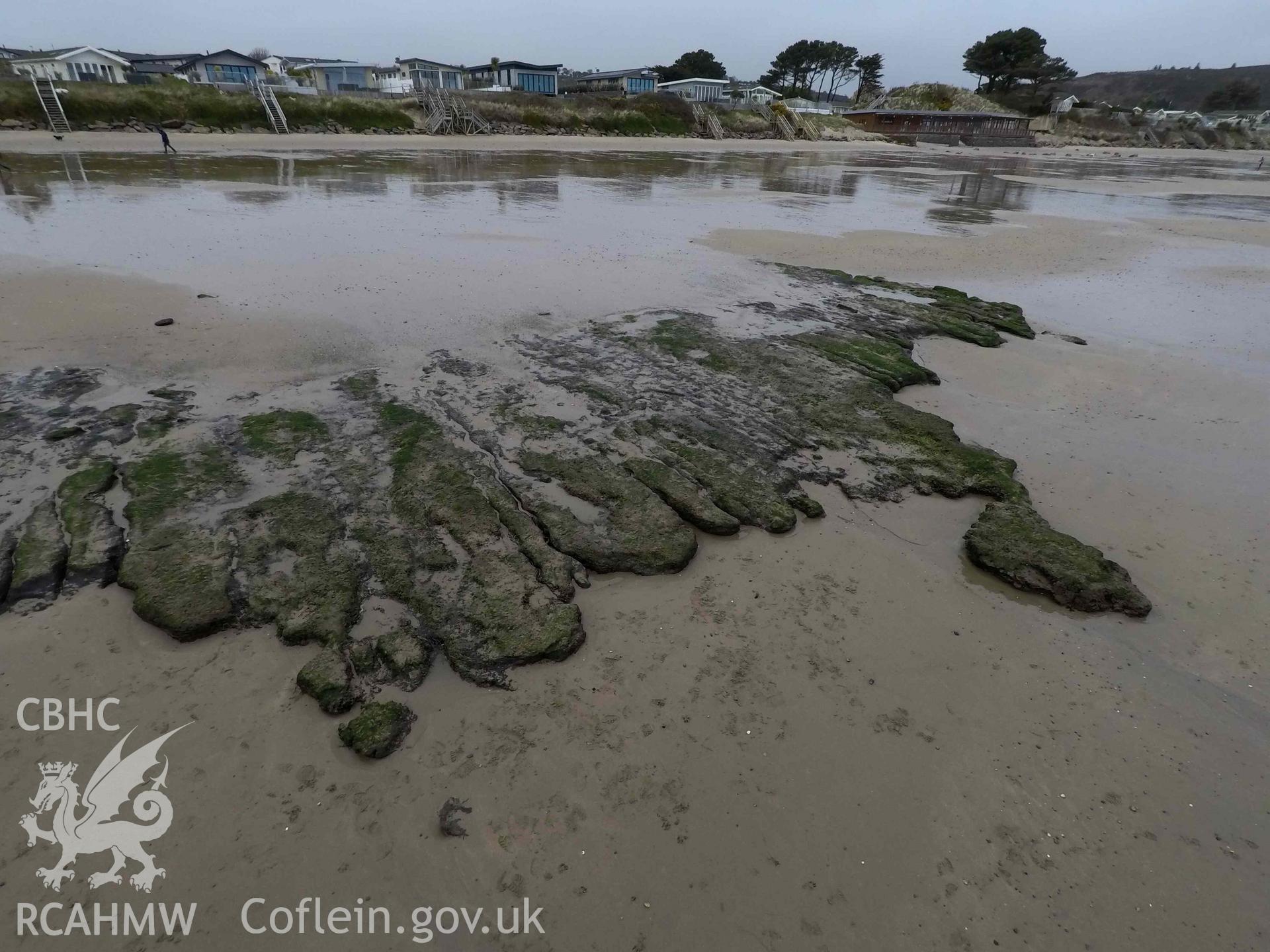 Peat exposure as recorded with pole camera. View looking west. Part of survey of the Submerged Forest, Peat Exposures and Footprints on The Warren Beach, Abersoch, conducted by Toby Driver on 29 March 2021. Produced with EU funds through the Ireland Wales Co-operation Programme 2014-2023. All material made freely available through the Open Government Licence.