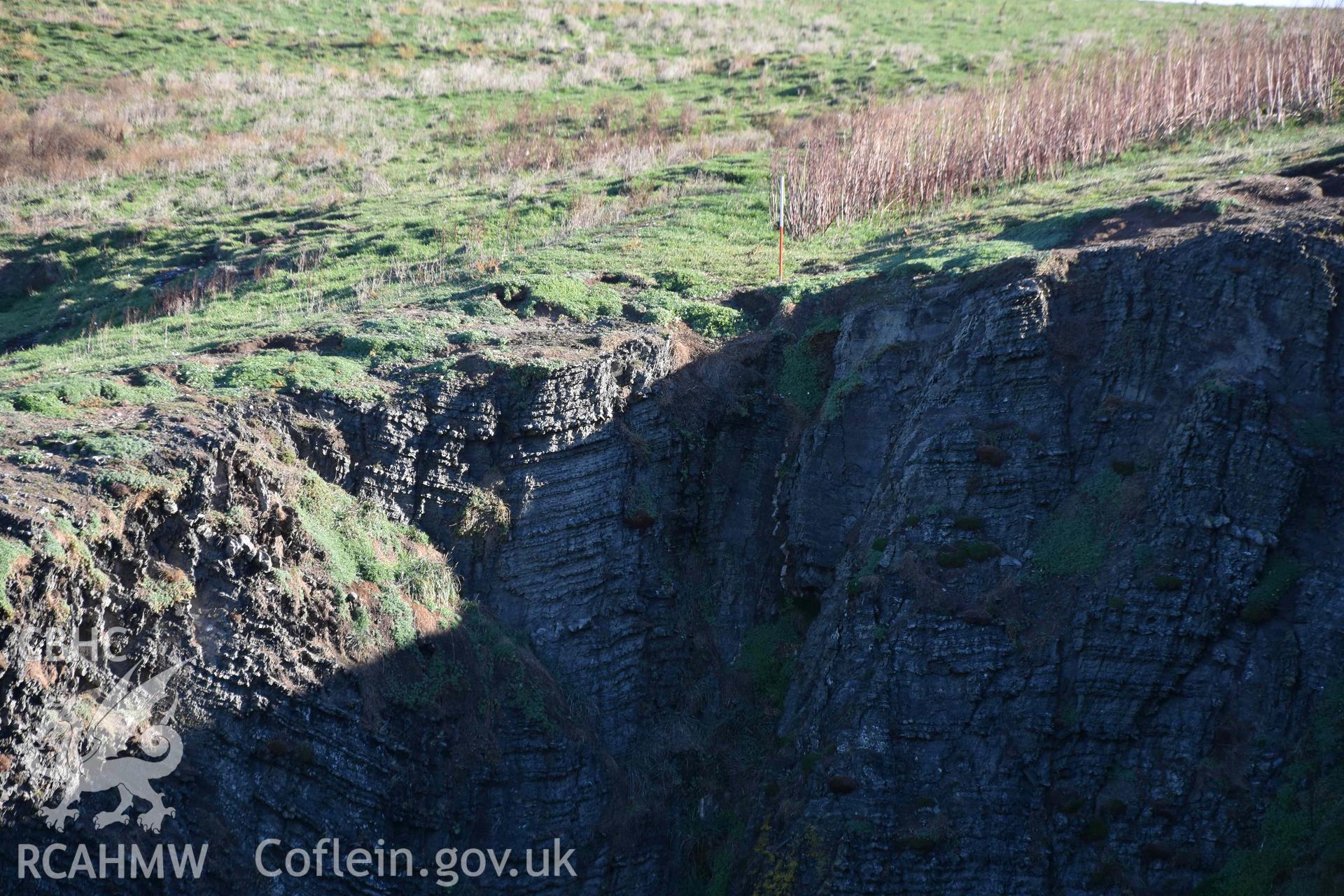 Western end of the promontory enclosure bank at the cliff edge.. Part of a digital photographic survey conducted on Cardigan Island by Louise Barker of RCAHMW on 30 October 2018. Produced with EU funds through the Ireland Wales Co-operation Programme 2014-2023. All material made freely available through the Open Government Licence.