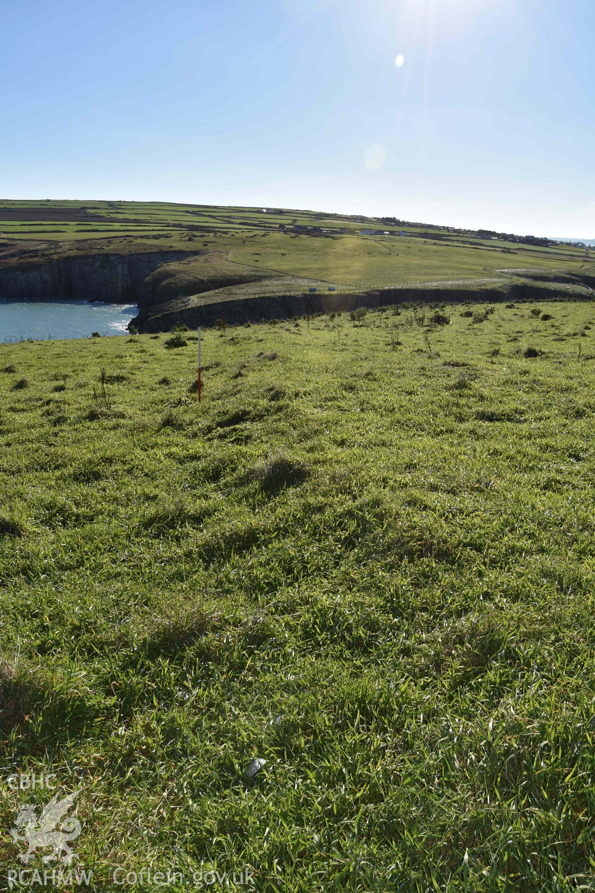 View looking southeast along bank defining the eastern side of the settlement enclosure on Cardigan Island. Part of digital photographic survey conducted by Louise Barker of RCAHMW on 30 October 2018. Produced with EU funds through the Ireland Wales Co-operation Programme 2014-2023. All material made freely available through the Open Government Licence.