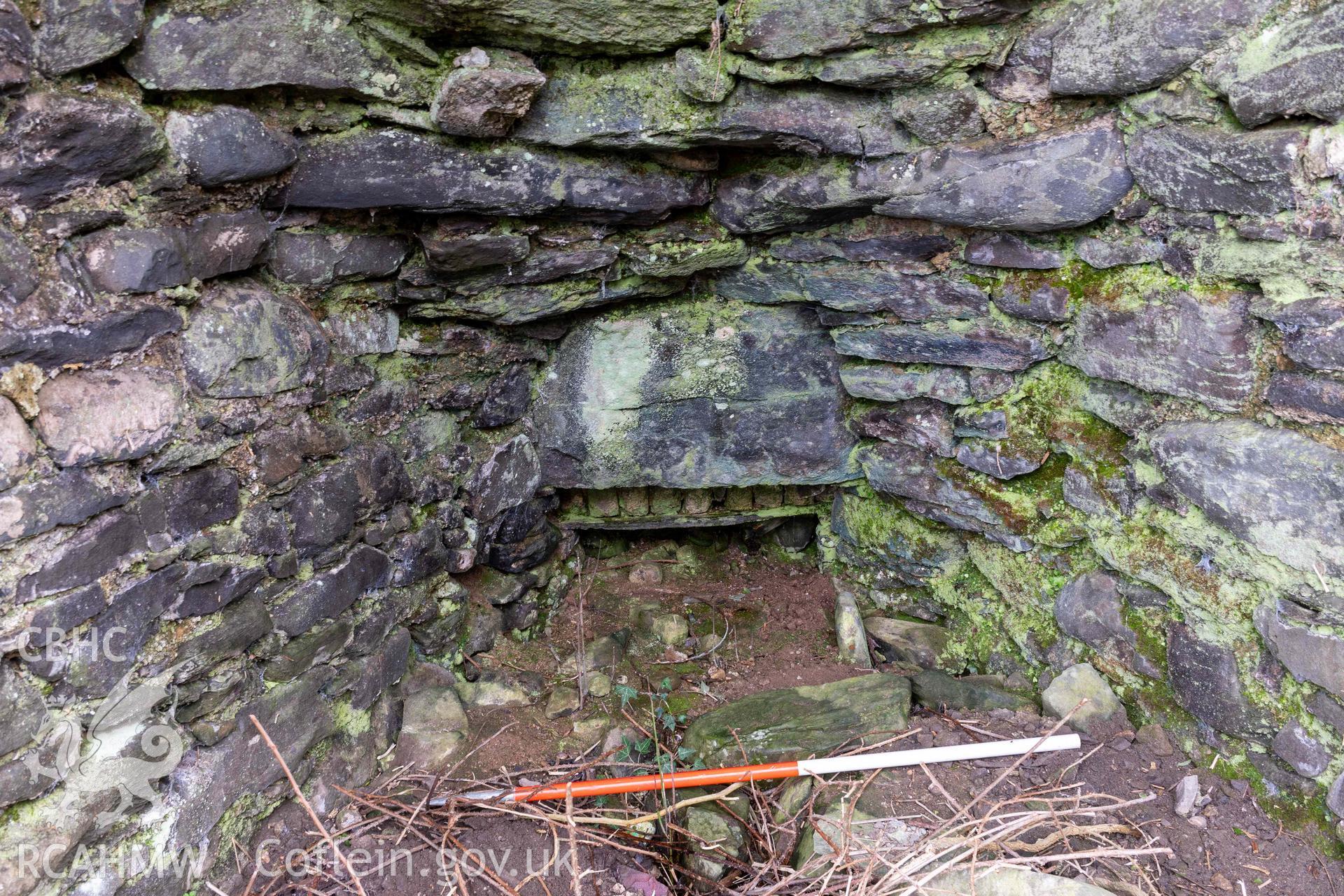Kiln 3, draw-hole in kiln-eye, west elevation (with scale). Part of photographic survey of Aberstrincell lime kilns and coal yard, conducted by Louise Barker of the RCAHMW survey team on 21 March 2024.