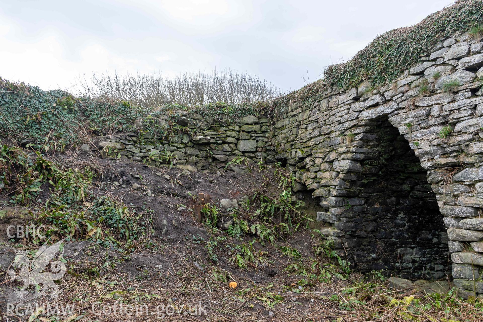 Rear (south) retaining wall between kilns 2 and 3, and east elevation kiln 3. Part of photographic survey of Aberstrincell lime kilns and coal yard, conducted by Louise Barker of the RCAHMW survey team on 21 March 2024.