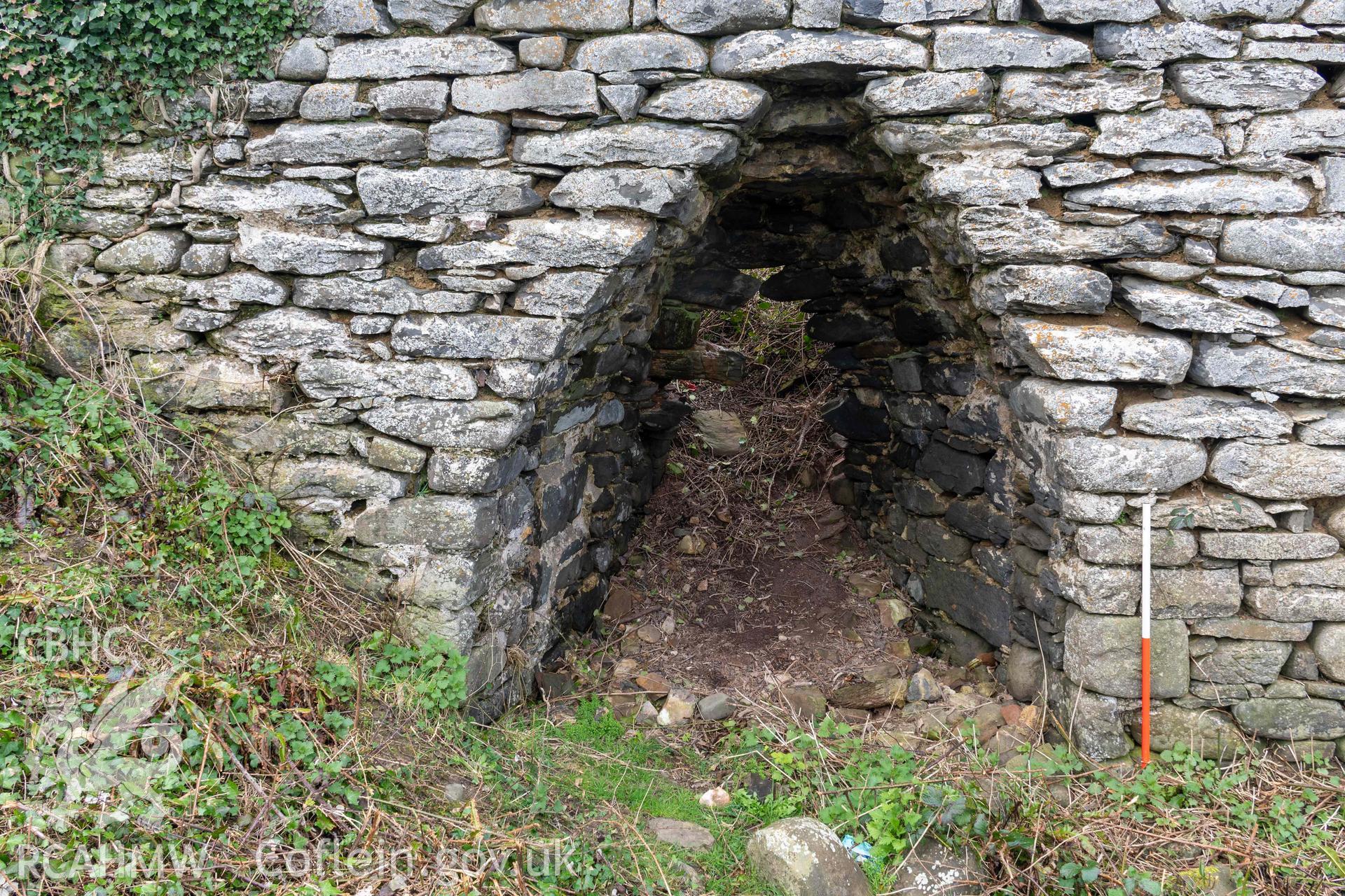 Kiln 1, kiln-eye, east elevation (with scale). Part of photographic survey of Aberstrincell lime kilns and coal yard, conducted by Louise Barker of the RCAHMW survey team on 21 March 2024.